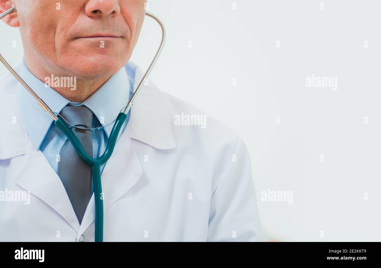 Medico caucasico di media età indossando camice da laboratorio, stetoscopio e fascetta elegante. Professionista sanitario. Tema industria medica. Foto Stock