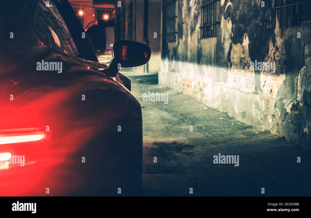 Concetto automobilistico. Auto di lusso moderna nel Dark City Alley durante le ore notturne. Luci posteriori del veicolo. Foto Stock
