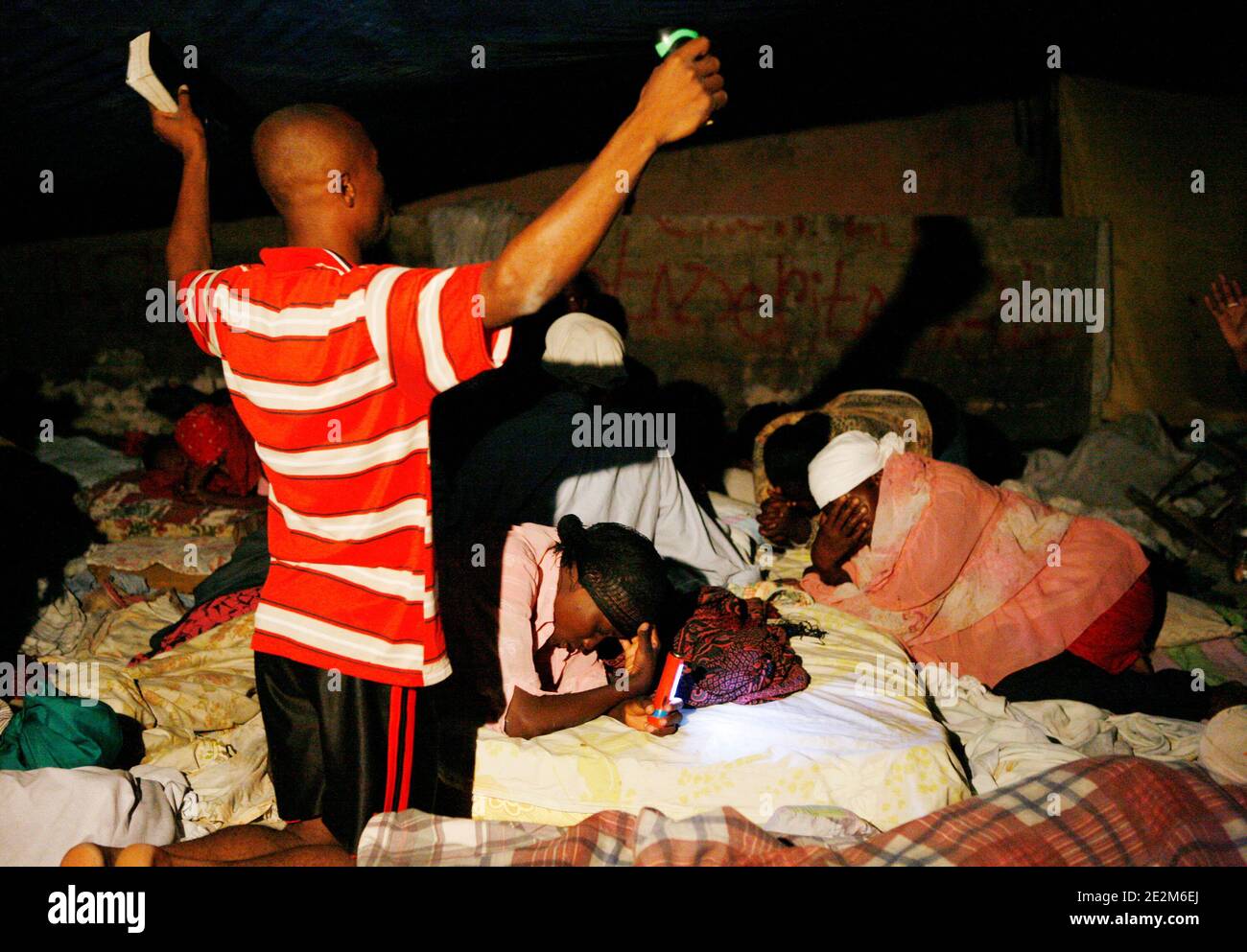 Il Battaglione brasiliano delle Nazioni Unite si reca in una pattuglia notturna per garantire la baraccopoli di Cite Soleil a Port-au-Prince, Haiti, il 21 gennaio 2010. Un gruppo di persone prega per strada perché la loro casa è stata distrutta nel terremoto che ha devastato Haiti martedì 12 gennaio. Foto di Sophia Paris/un via ABACAPRESS.COM Foto Stock