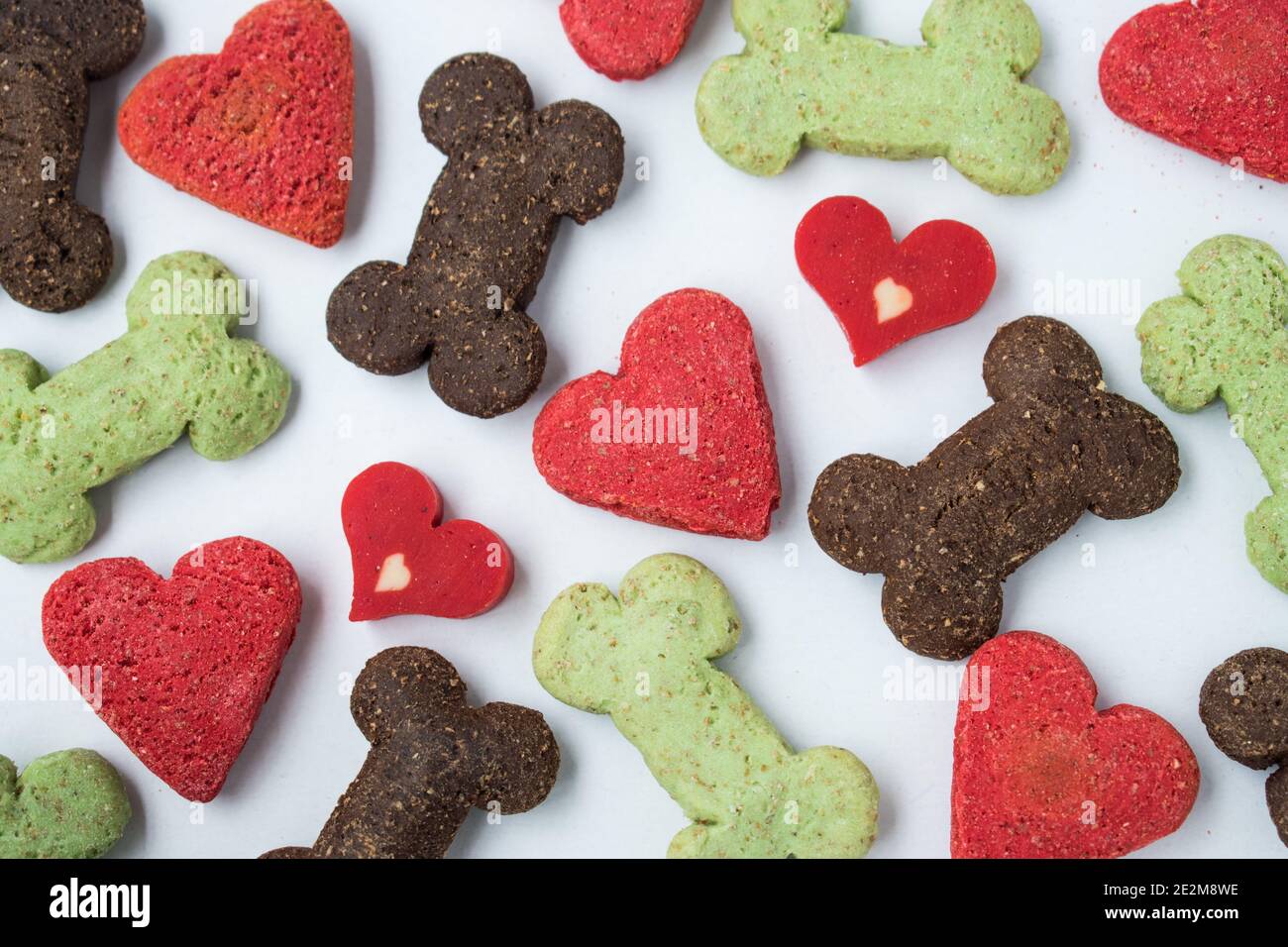 Molti biscotti differenti del cane dei cuori e delle ossa su un sfondo bianco Foto Stock