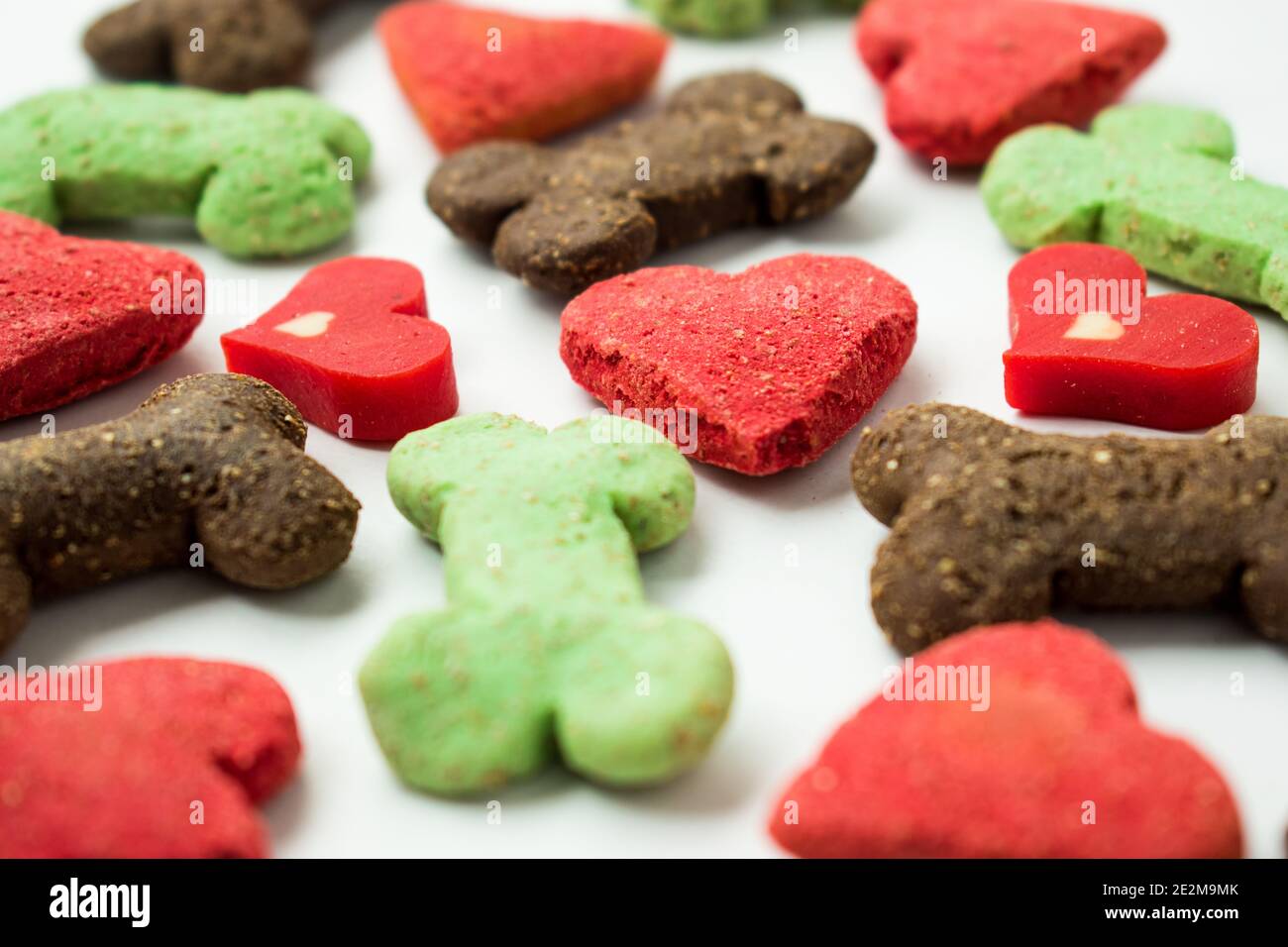 Molti biscotti differenti del cane dei cuori e delle ossa su un sfondo bianco Foto Stock