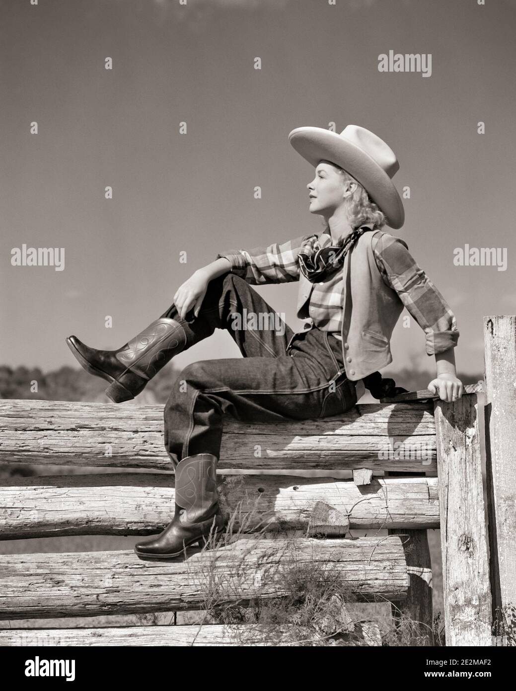 COWGIRL BIONDA ANNI '40 CHE INDOSSA UN GRANDE CAPPELLO COWBOY CON BRIMMED SEDUTO DENTRO PROFILO SU RECINZIONE CORRAL IN PLAID CAMICIA BANDANA STIVALI BLU JEANS - G3077 HAR001 HARS SALUTE VITA DOMESTICA STATI UNITI SPAZIO FOTOCOPIE A LUNGHEZZA INTERA PER DONNE NEGLI STATI UNITI D'AMERICA PLAID CONFIDENZA DENIM GEST B&W AMERICA DEL NORD LIBERTÀ NORD AMERICA SOGNI LOG BASSO ANGOLO COWGIRL CORRAL IN BANDANA POSA GALLONE 10 JEANS BLU ELEGANTI E RIMBATTI INFORMALI IN TWILL GIOVANE ADULTO DONNA NERO E BIANCO CASUAL ETNIA CAUCASICA HAR001 VECCHIO STILE Foto Stock