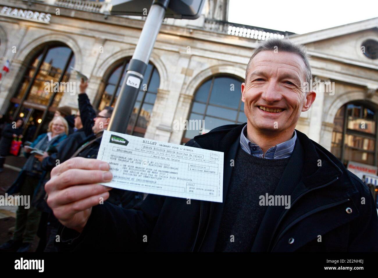 Il sindaco Jean-Francois Caron di Loos-en-Gohelle, capo della lista del partito 'Europe Ecologie' per la regione Nord-Pas-de-Calais per le elezioni regionali del 7 marzo, tiene un opuscolo di campagna sotto forma di biglietto ferroviario mentre si batte a Lille, nel nord della Francia Foto Stock