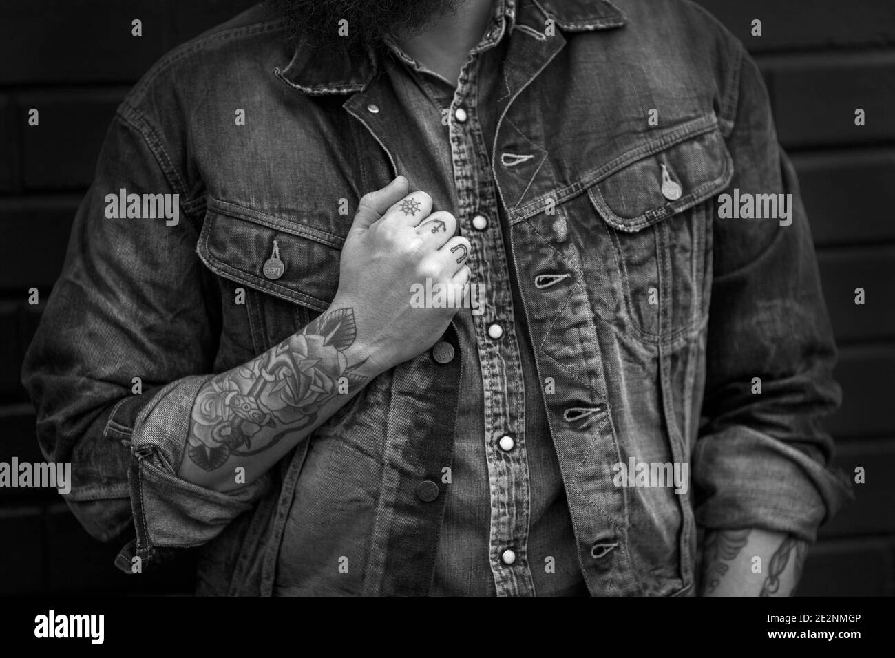 Uomo che indossa jeans jeans jeans jeans con camicie tatuate Foto Stock