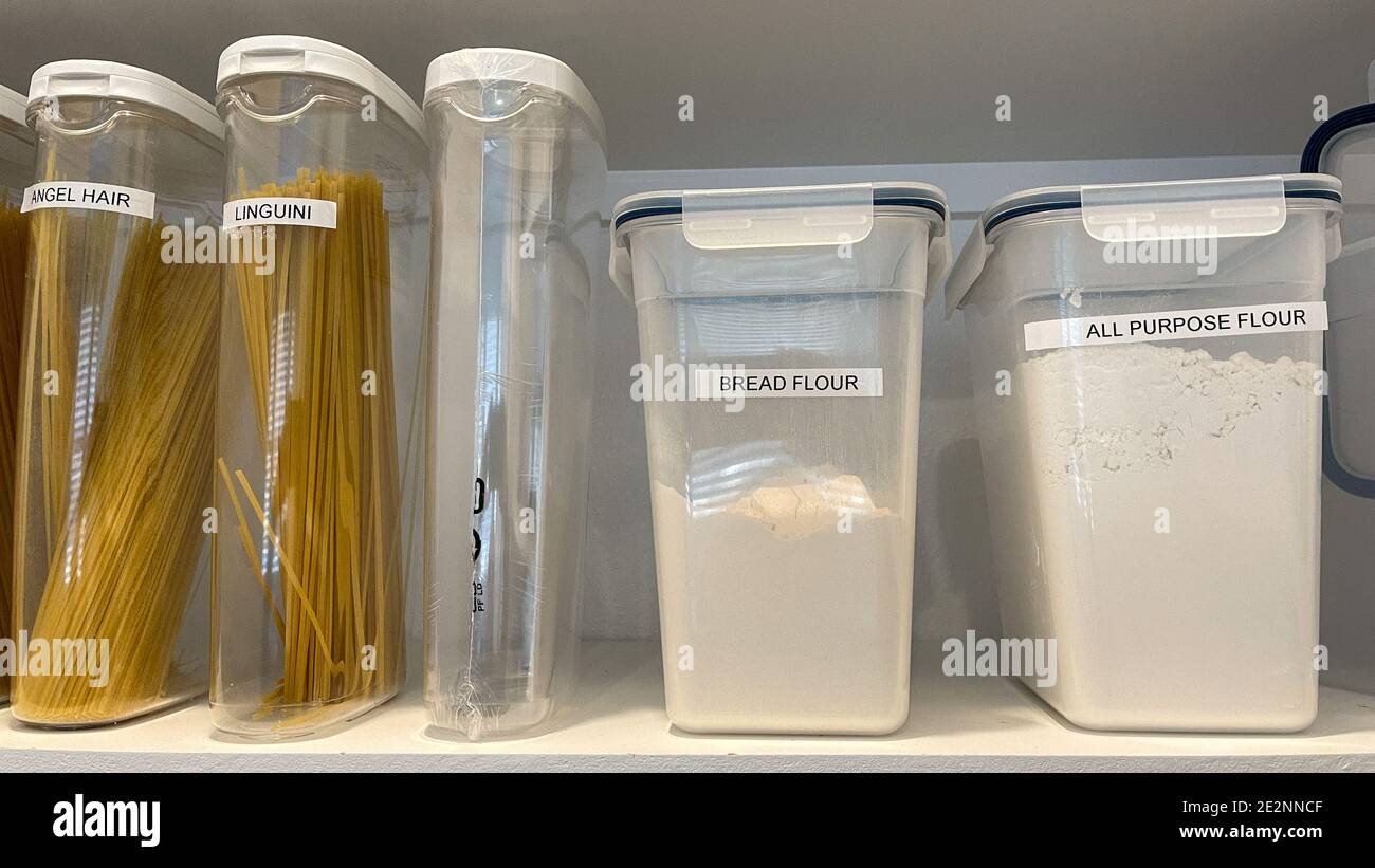 Un ripiano organizzato per dispensa con vari tipi di pasta e farina in  contenitori di plastica Foto stock - Alamy