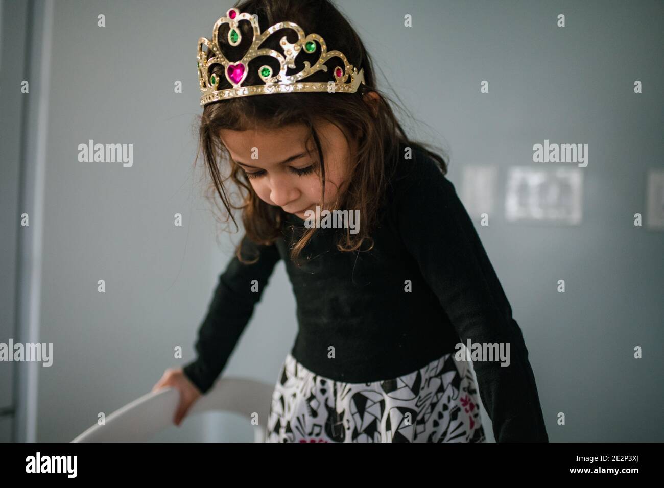 ragazza di 4 anni che indossa tiara guardando verso il basso Foto Stock