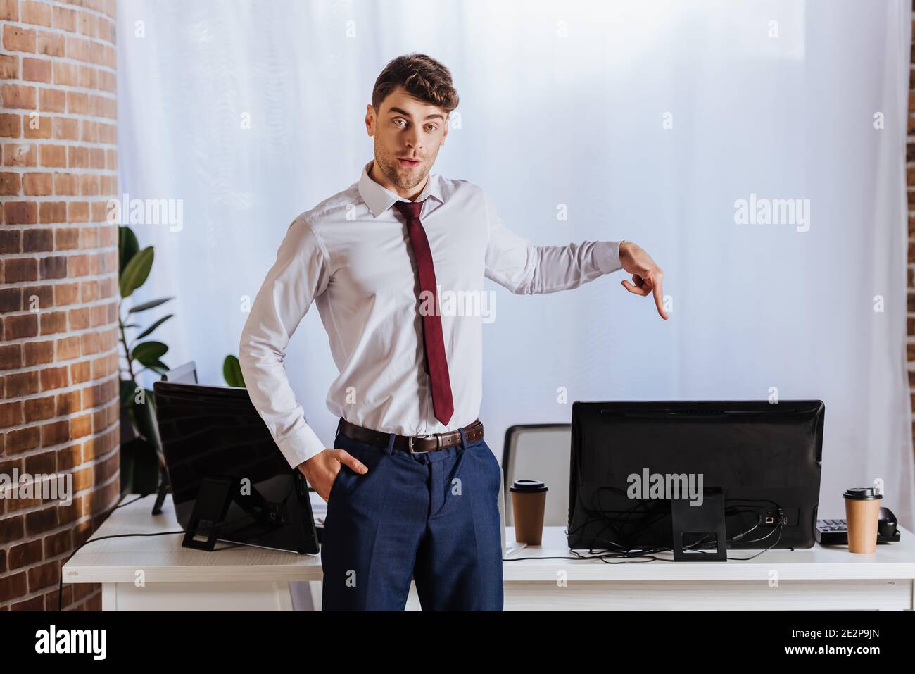 Forex uomo d'affari che punta con il dito al computer in ufficio Foto Stock