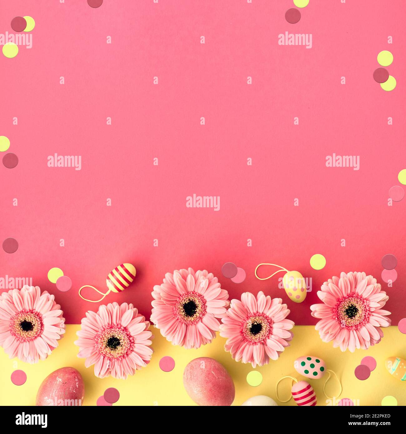 Appartamento pasquale giaceva in giallo e corallo con uova dipinte e gerbera margherita, composizione quadrata con copy-space Foto Stock