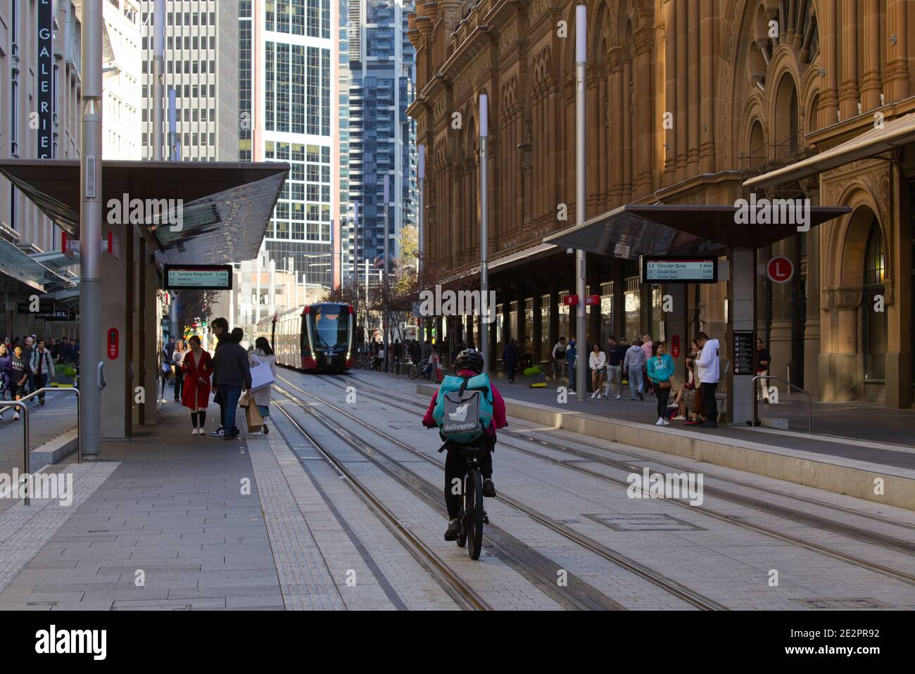 Autista della consegna di cibo su una bicicletta che opera illegalmente in tram Tracce Sydney Australia Foto Stock