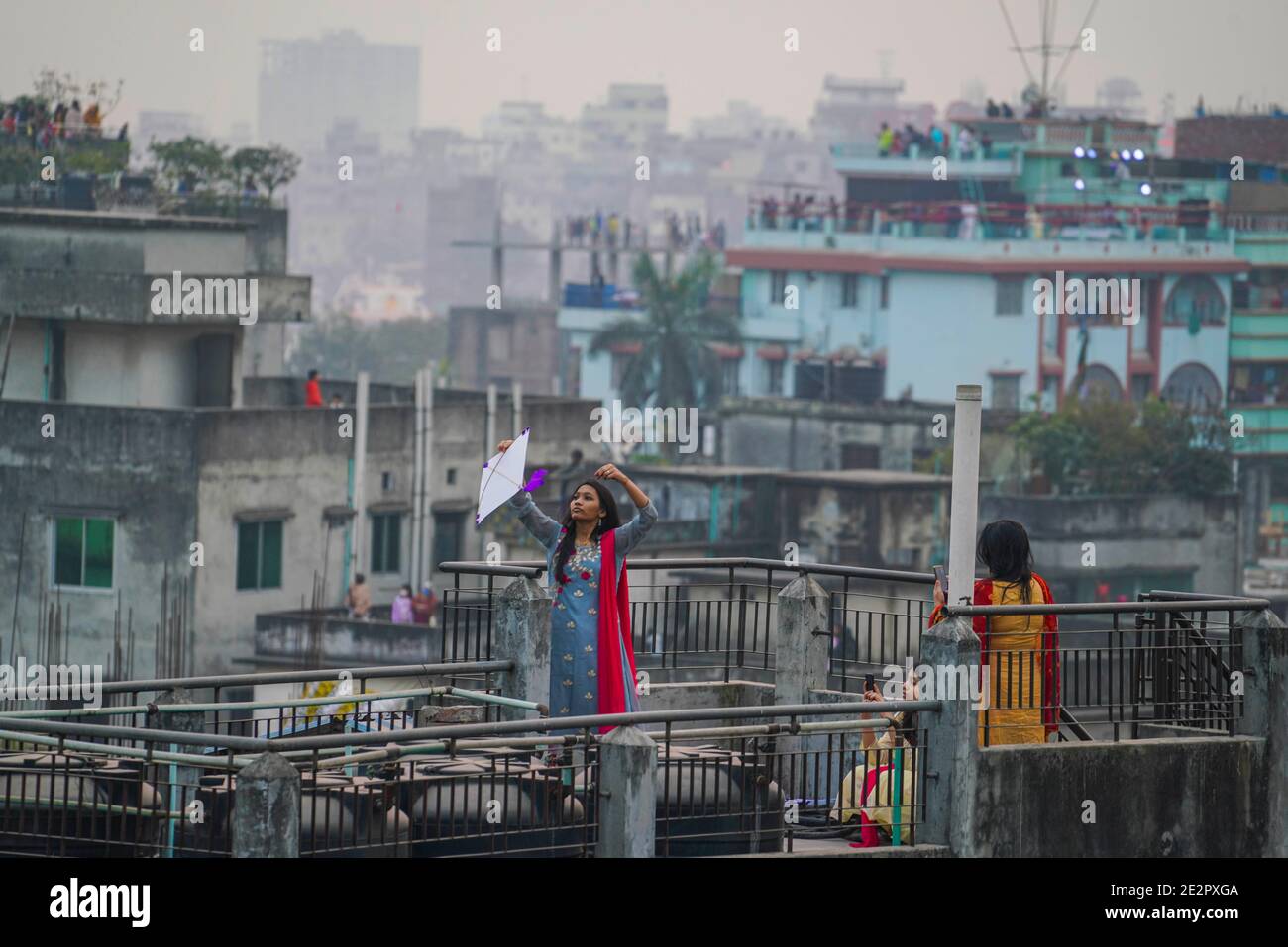 Una ragazza del Bangladesh cerca di volare kite sul tetto durante il festival Shakrain o il festival Kite. Shakrain Festival è una celebrazione annuale a Dhaka, Bangladesh, osservato con il volo di aquiloni. Si verifica alla fine di Poush, il nono mese del calendario bengalese. Questa giornata è conosciuta come Poush Sangkranti. Shakrain Festival è uno dei più antichi festival annuali del Bangladesh. Foto Stock