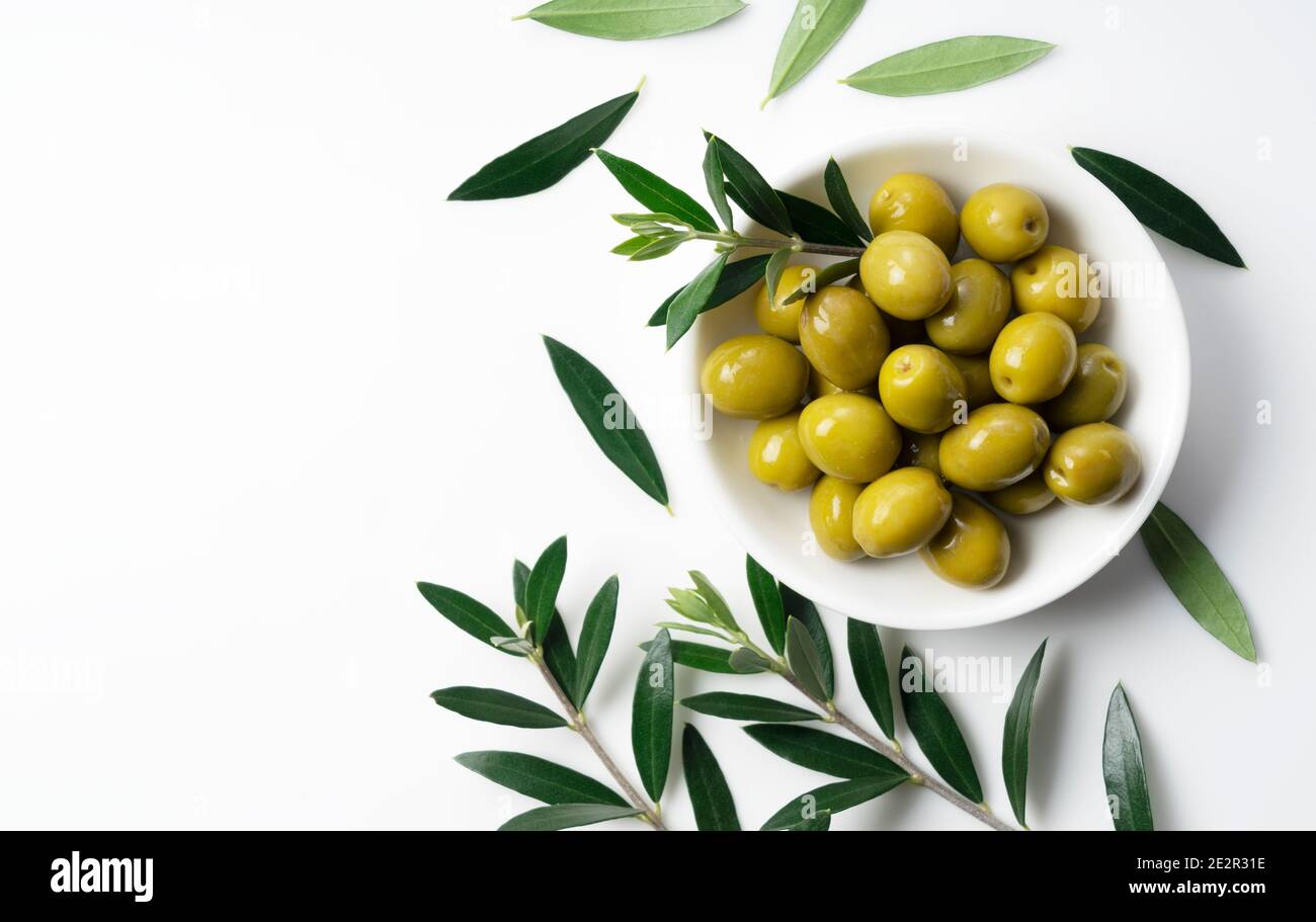 Rami di olive con olive salate poste su fondo bianco con spazio per la copia. Vista dall'alto Foto Stock