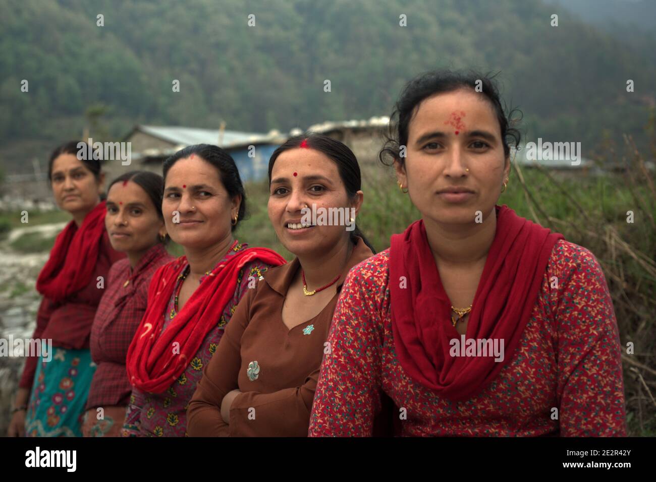 Ritratto di donne, abitanti di Khahare, in quanto si trovano vicino a un muro di gabione sul lato della pianura alluvionale di Harpan Khola nel distretto di Kaski, Gandaki, Nepal. Queste donne sono sopravvissute alle inondazioni e alle frane causate dalle piogge torrenziali nella zona di Bhaudare Tamagi, pochi mesi dopo i terremoti del 2015 (aprile-maggio 2015) in Nepal. Foto Stock