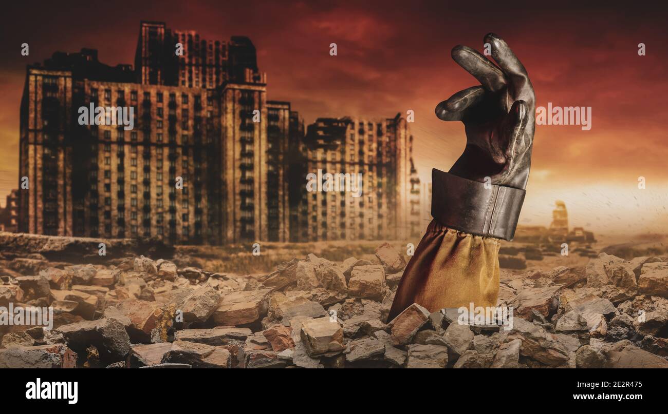Foto di una mano di stalker in guanto di gomma sepolta sotto mattoni sulla città apocalittica desolata. Foto Stock