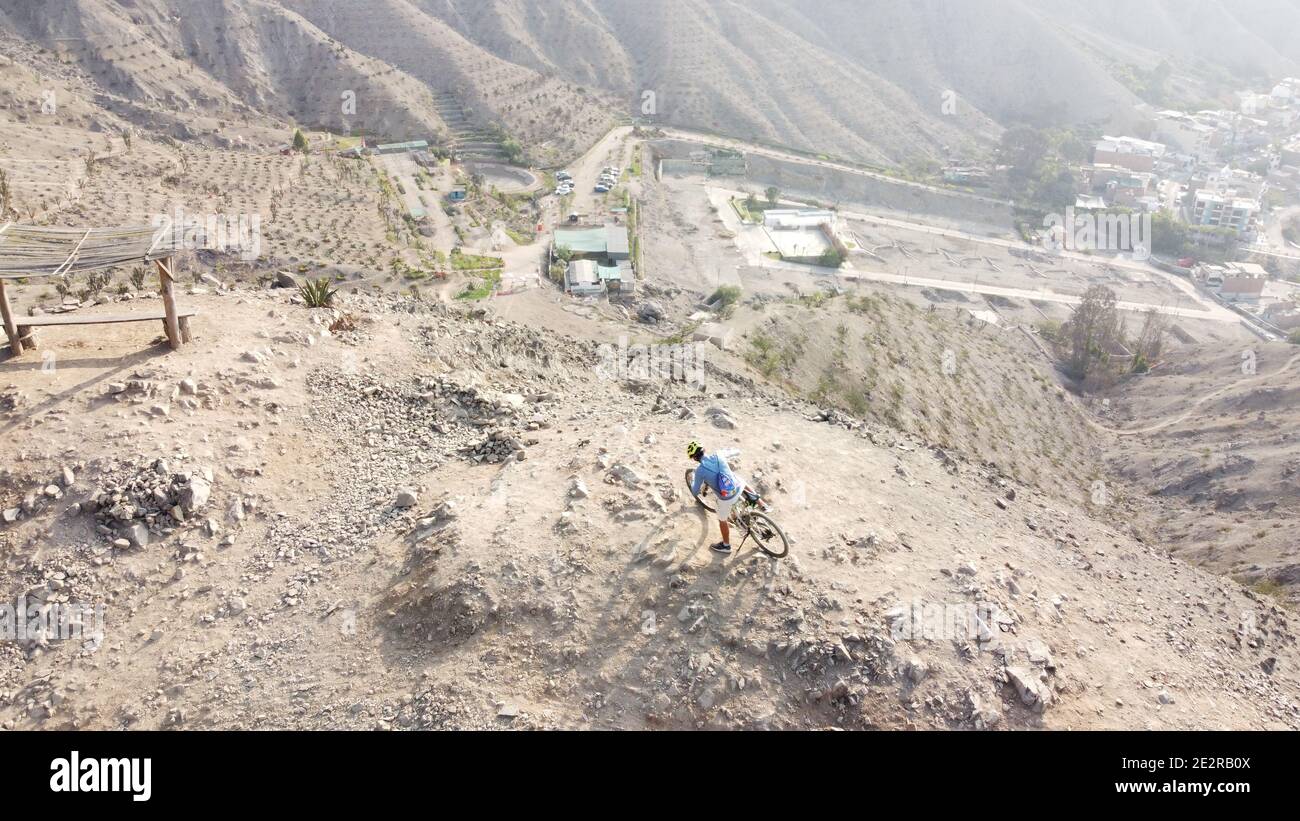 Uomo che cavalcano mountain bike lungo il terreno roccioso arido Foto Stock