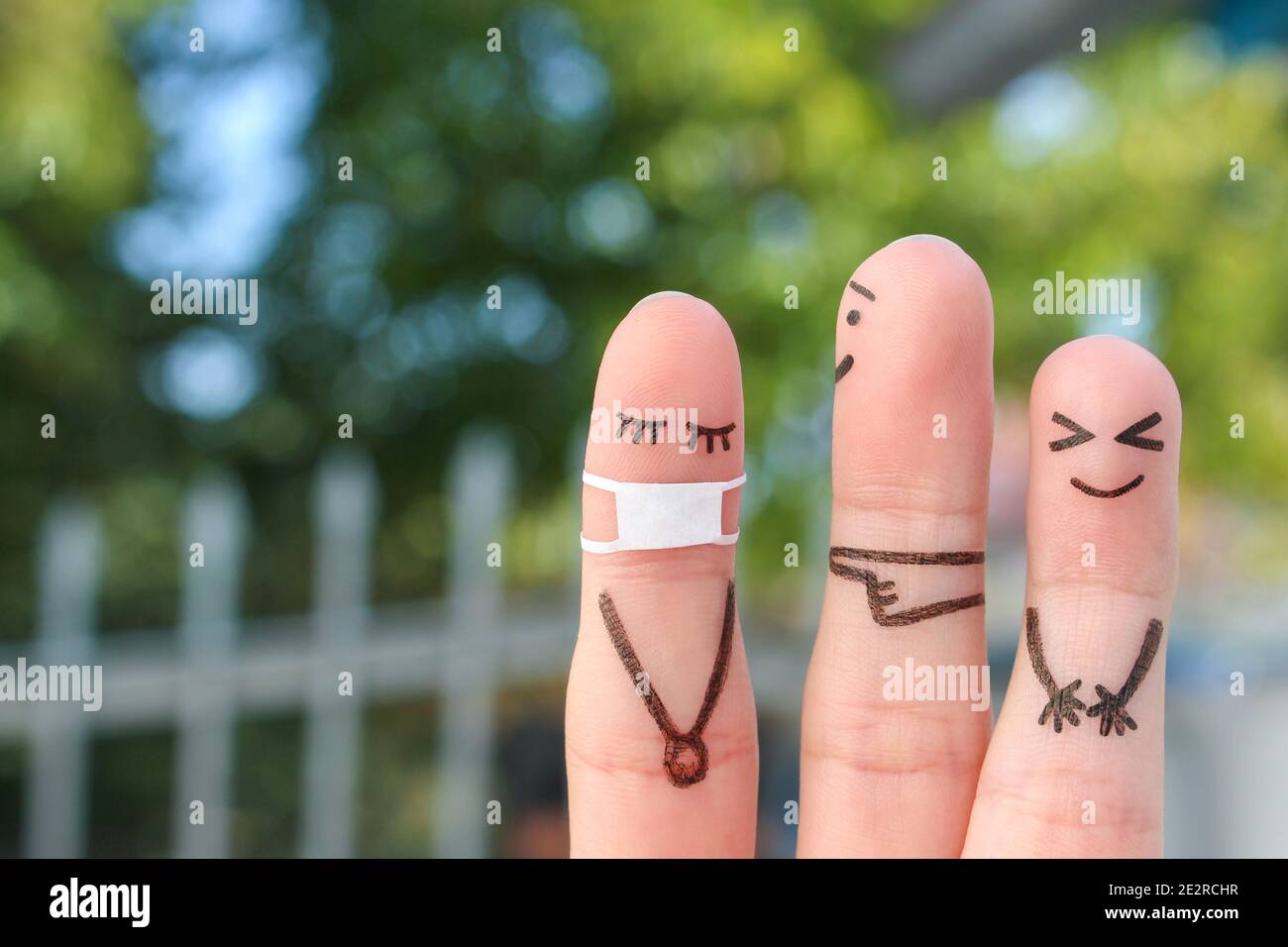 L'arte delle dita delle persone. Concetto bambini che bullono il loro compagno di classe in maschera medica da COVID-2019. Foto Stock