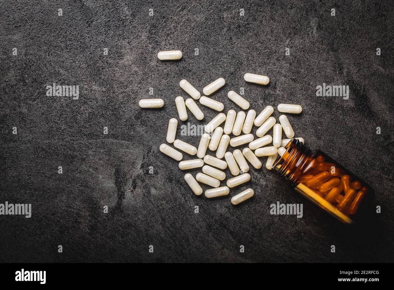 Pillole mediche bianche in contenitore. Pillole, compresse e capsule di medicina farmaceutica in vaso di vetro. Vista dall'alto. Foto Stock
