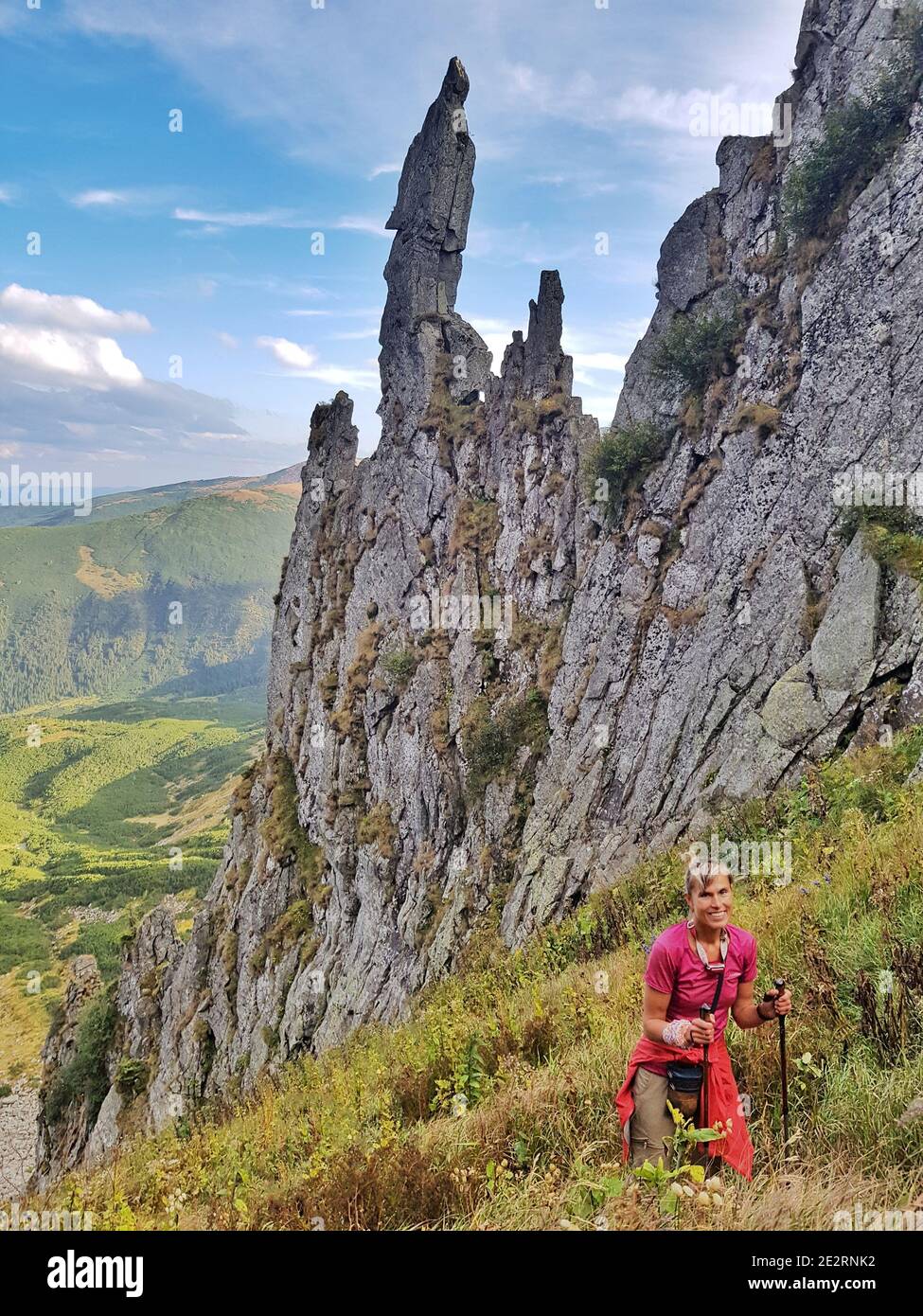 Donna in abiti luminosi sale il Monte Spitzi. Escursioni nei Monti Carpazi. Foto Stock