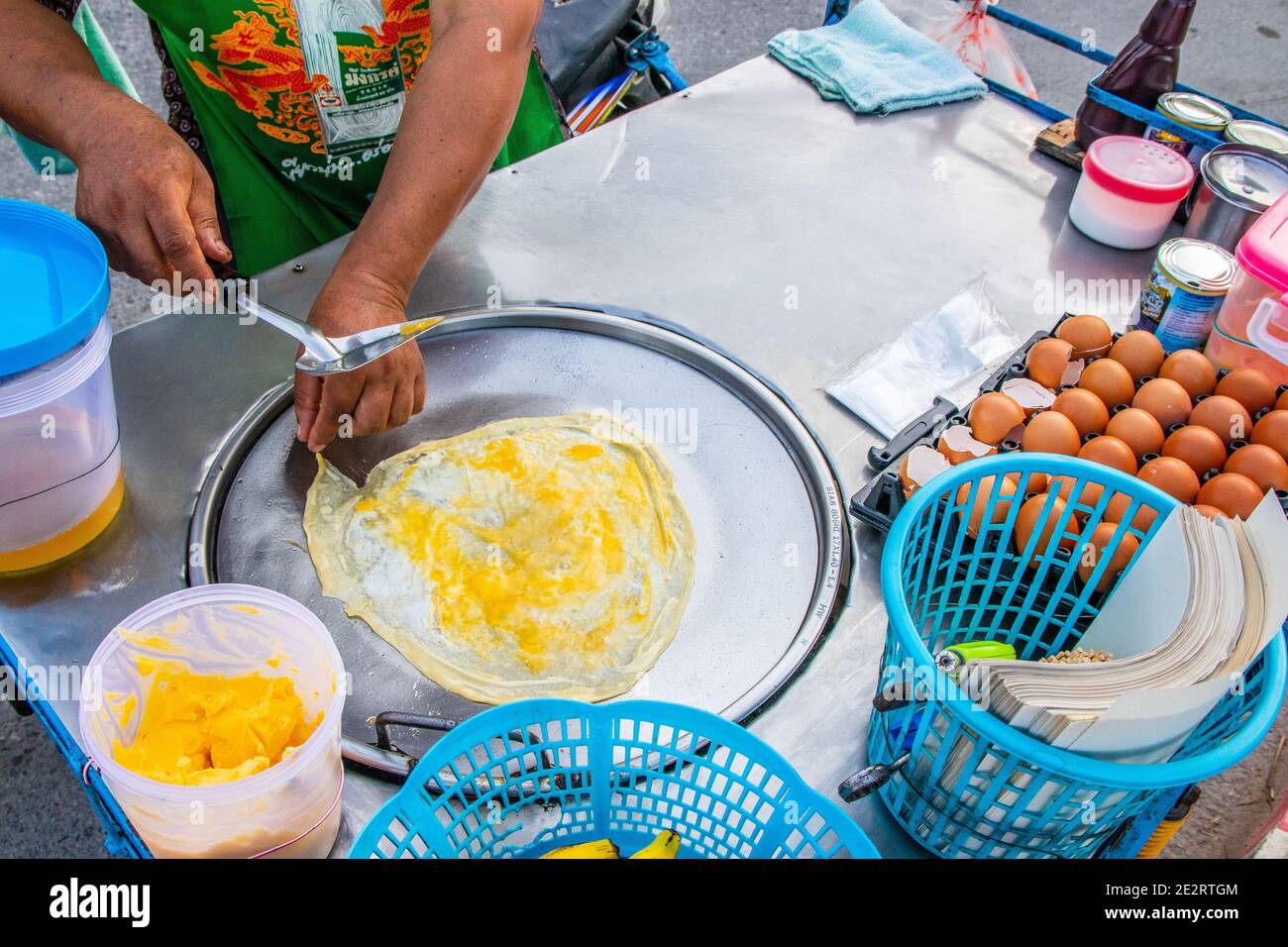 Preparazione di deliziosi pancake con un ripieno di banana a Negozio mobile Street food in Thailandia Foto Stock