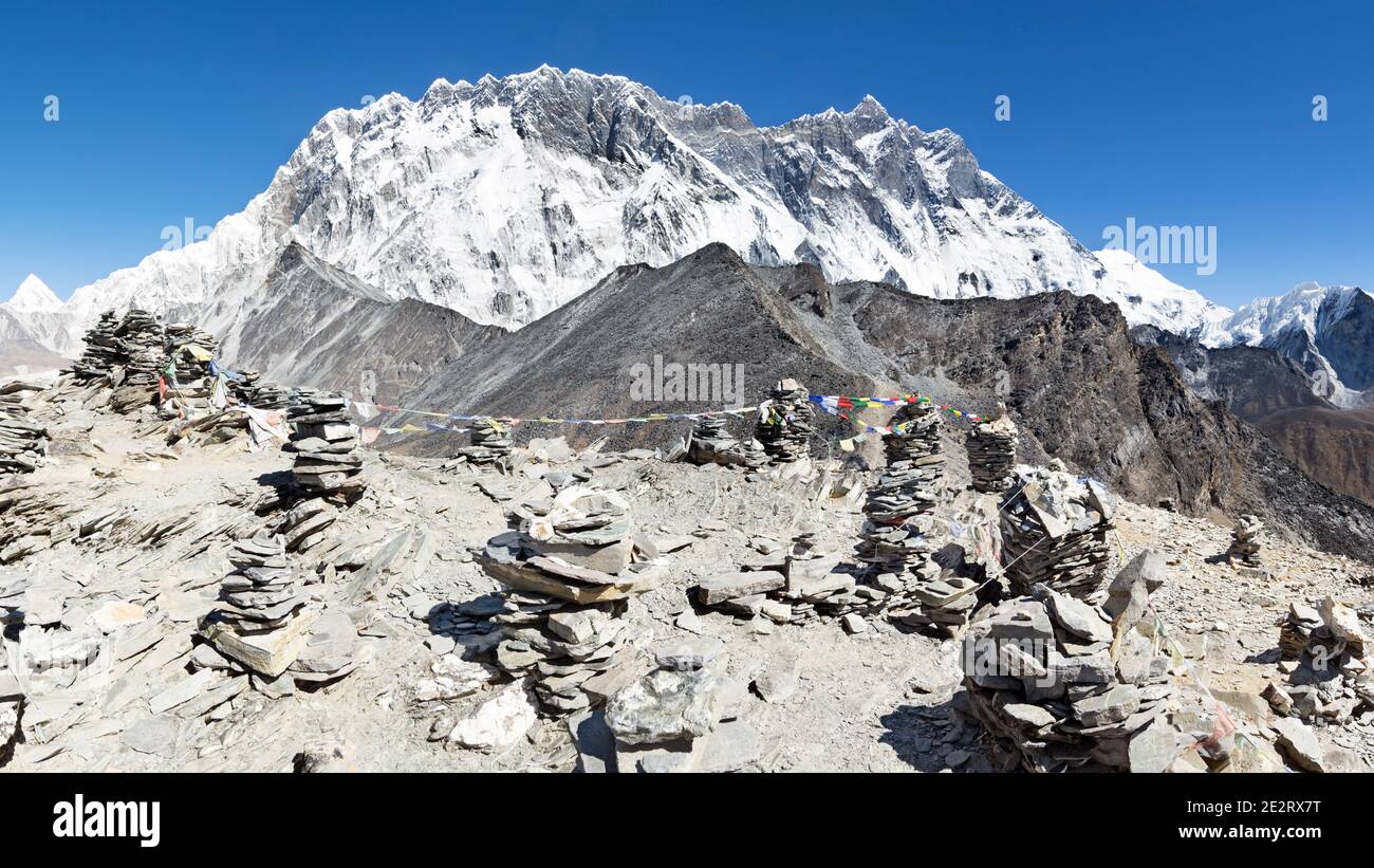 Vista dalla cima della collina Chhukung oltre il Lhotse parete con rock cairns in primo piano, Sagarmatha, Khumbu, in Nepal Foto Stock