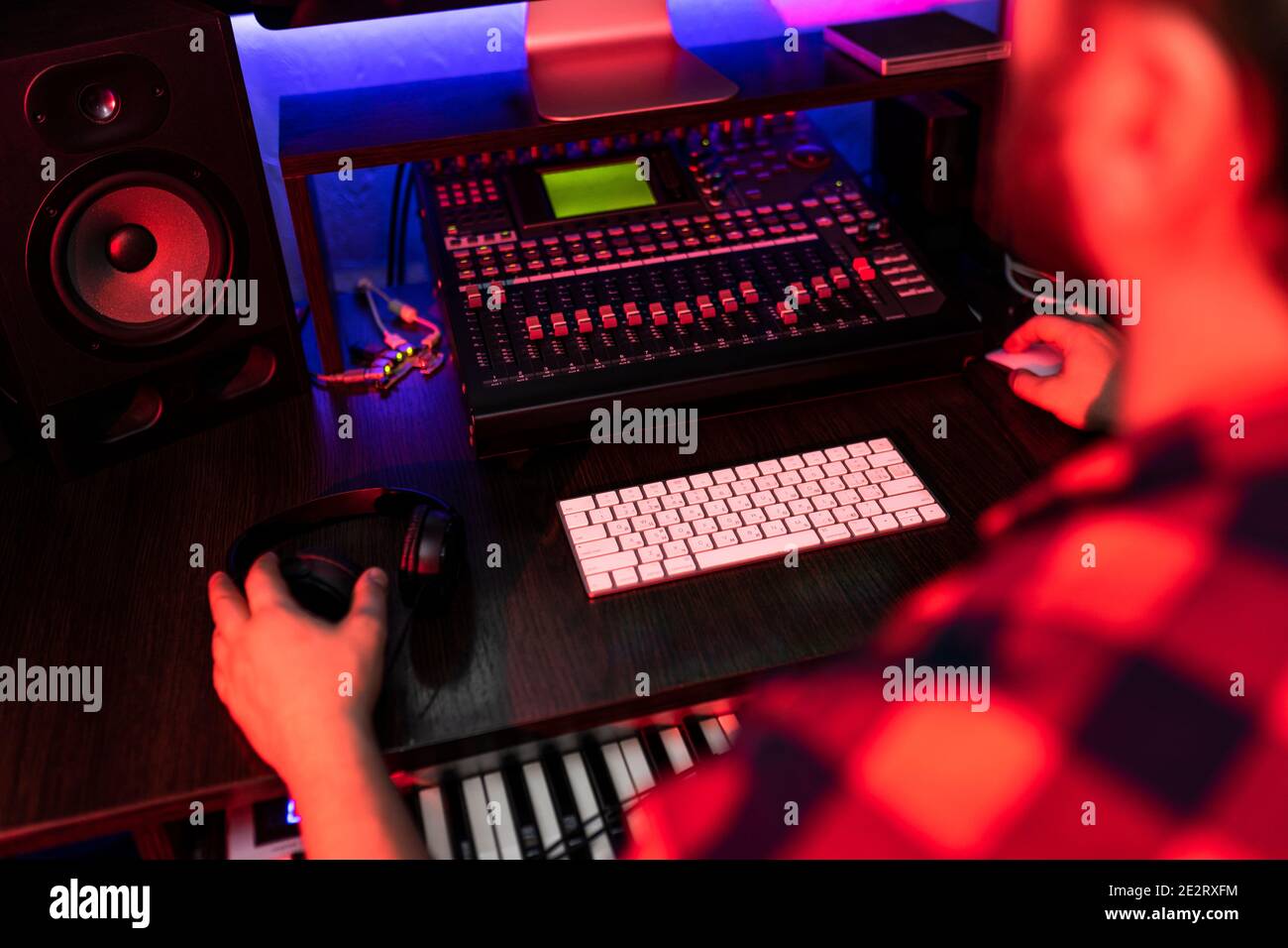 Producer maschio sta lavorando al mixer con audio e traccia nello studio di registrazione. Foto Stock