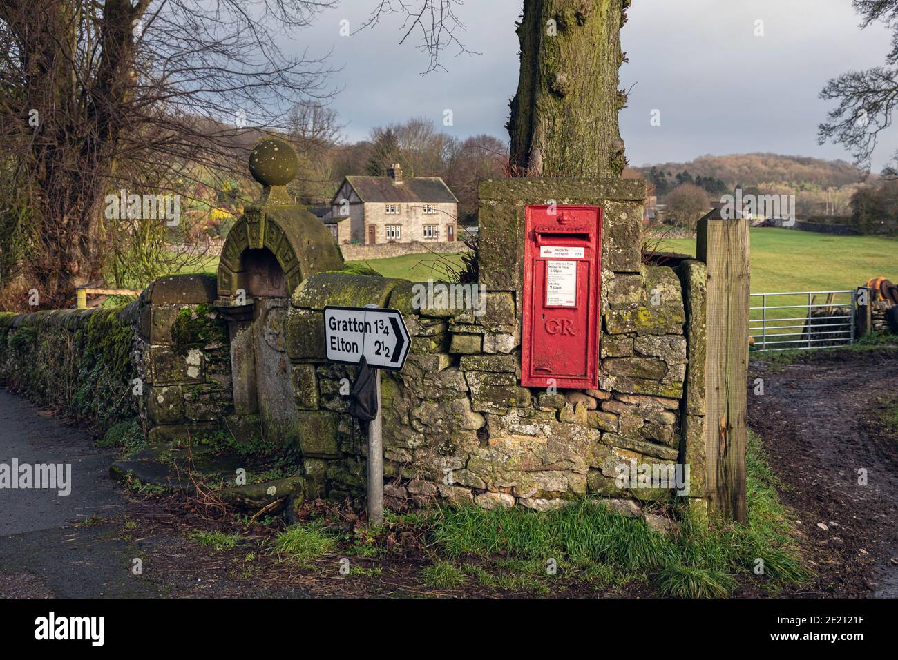 Un villaggio postbox vicino e vecchio bene a Middleton-by-Youlgrave, Peak District National Park, Derbyshire Foto Stock