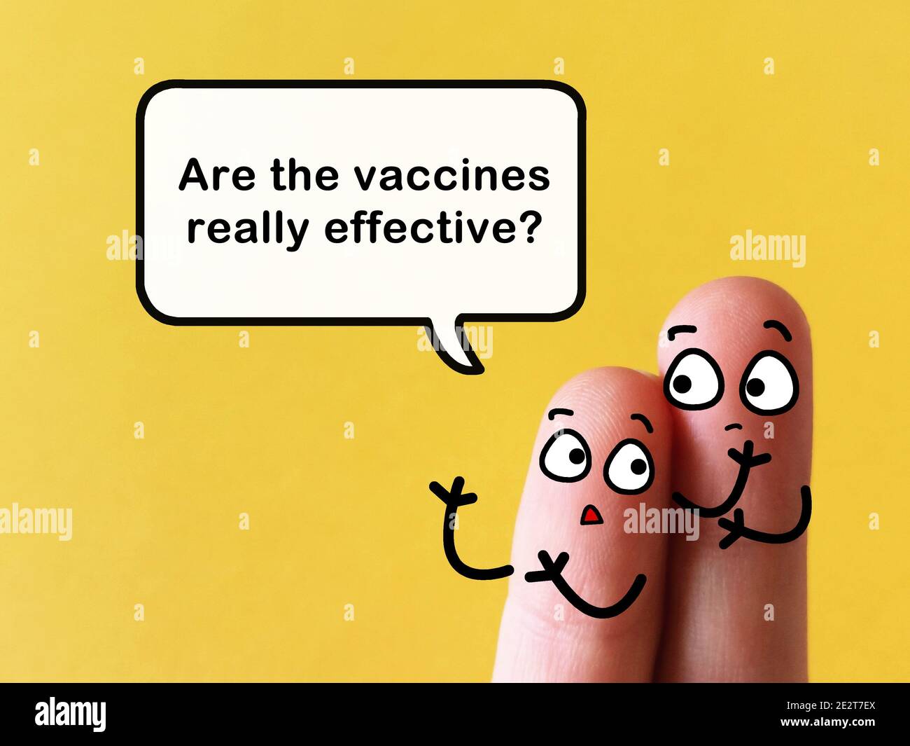Due dita sono decorate come due persone. Uno di loro sta chiedendo ad un altro se i vaccini sono realmente efficaci. Foto Stock
