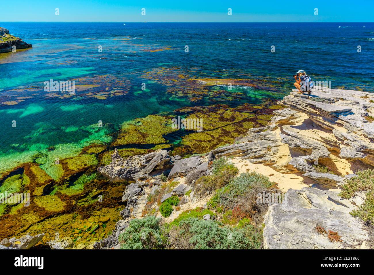 Concetto di scoperta del viaggio dell'Australia occidentale. Fotografo di viaggio sulle rocce a Jeannies Lookout, Rottnest Island, Australia occidentale. Femmina con Foto Stock