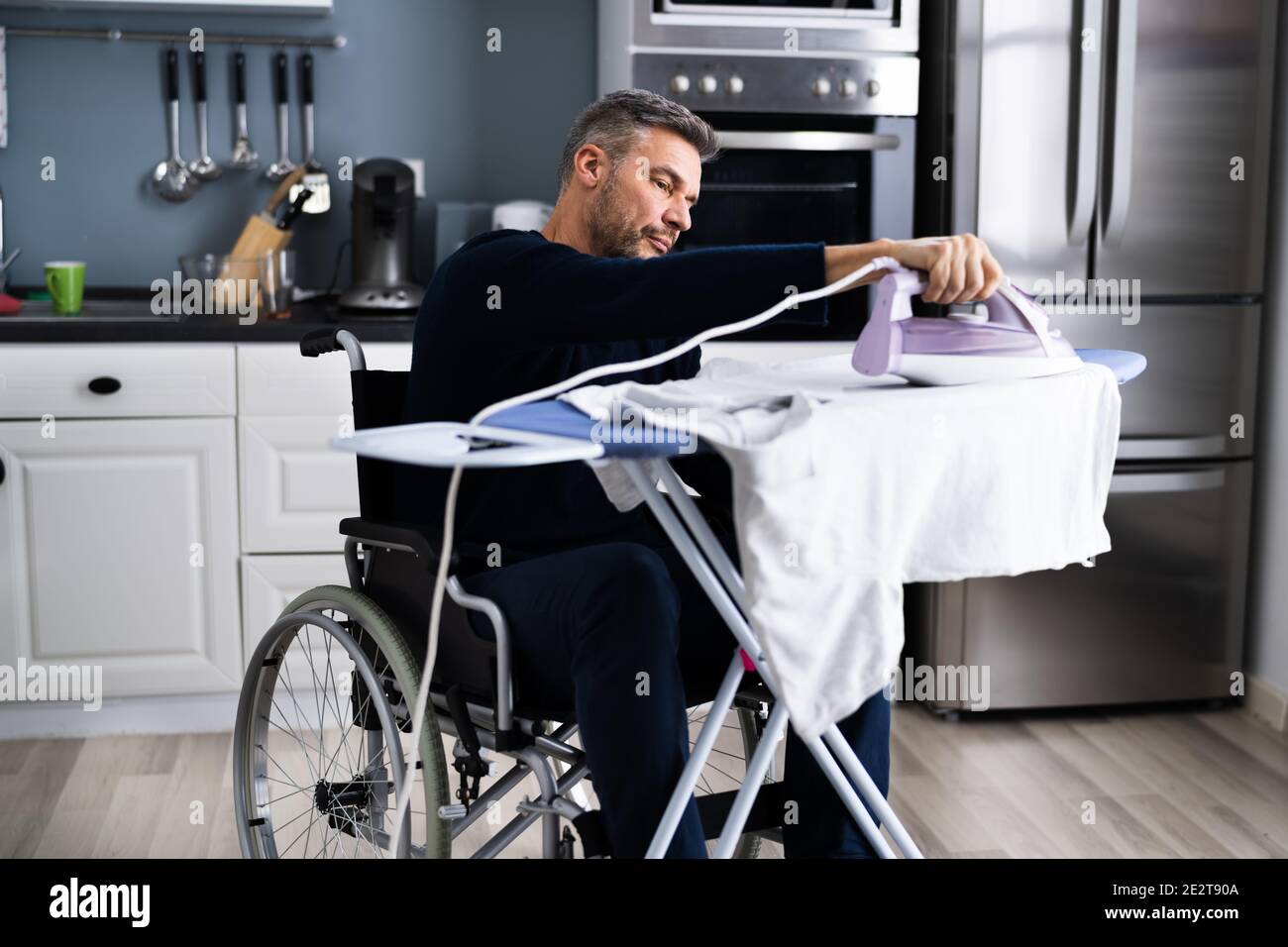 Uomo disabili in abiti da stiro per sedie a rotelle Foto Stock