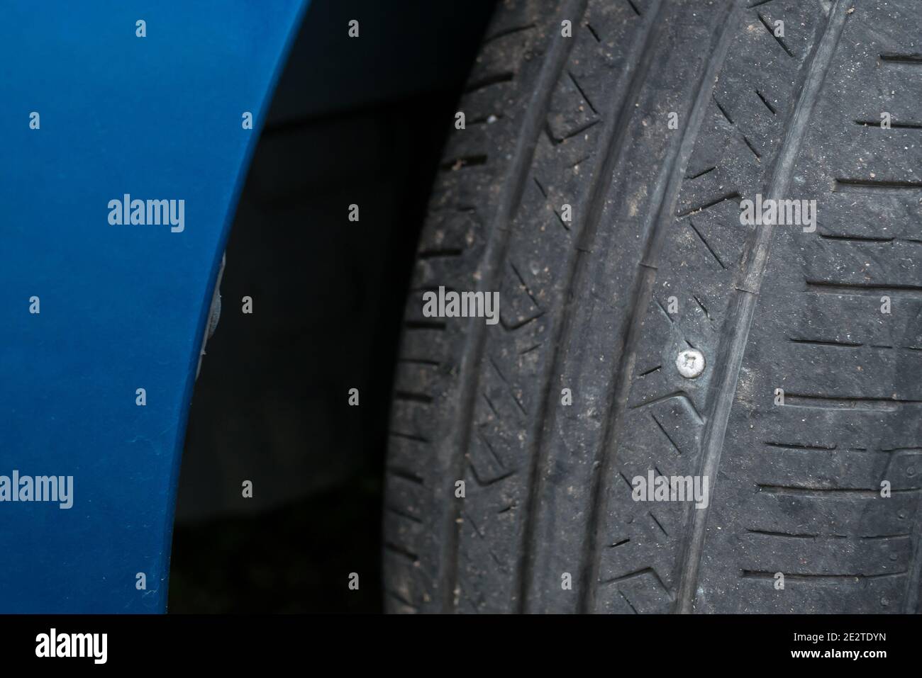 Vista ravvicinata della vite metallica forata nella vettura pneumatico Foto Stock