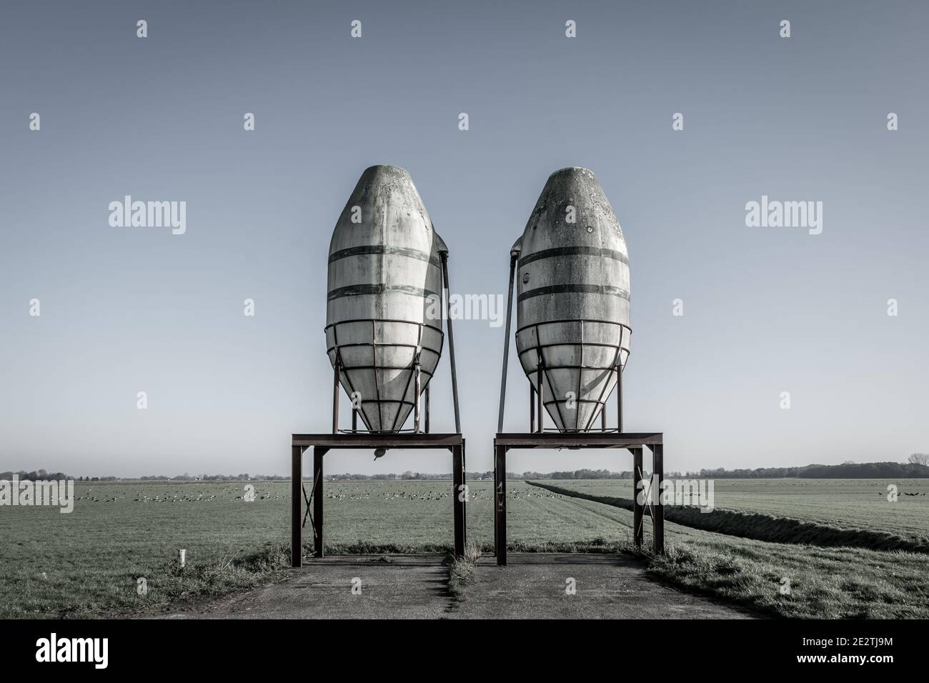 2 vecchi silos vicino al terreno agricolo Foto Stock