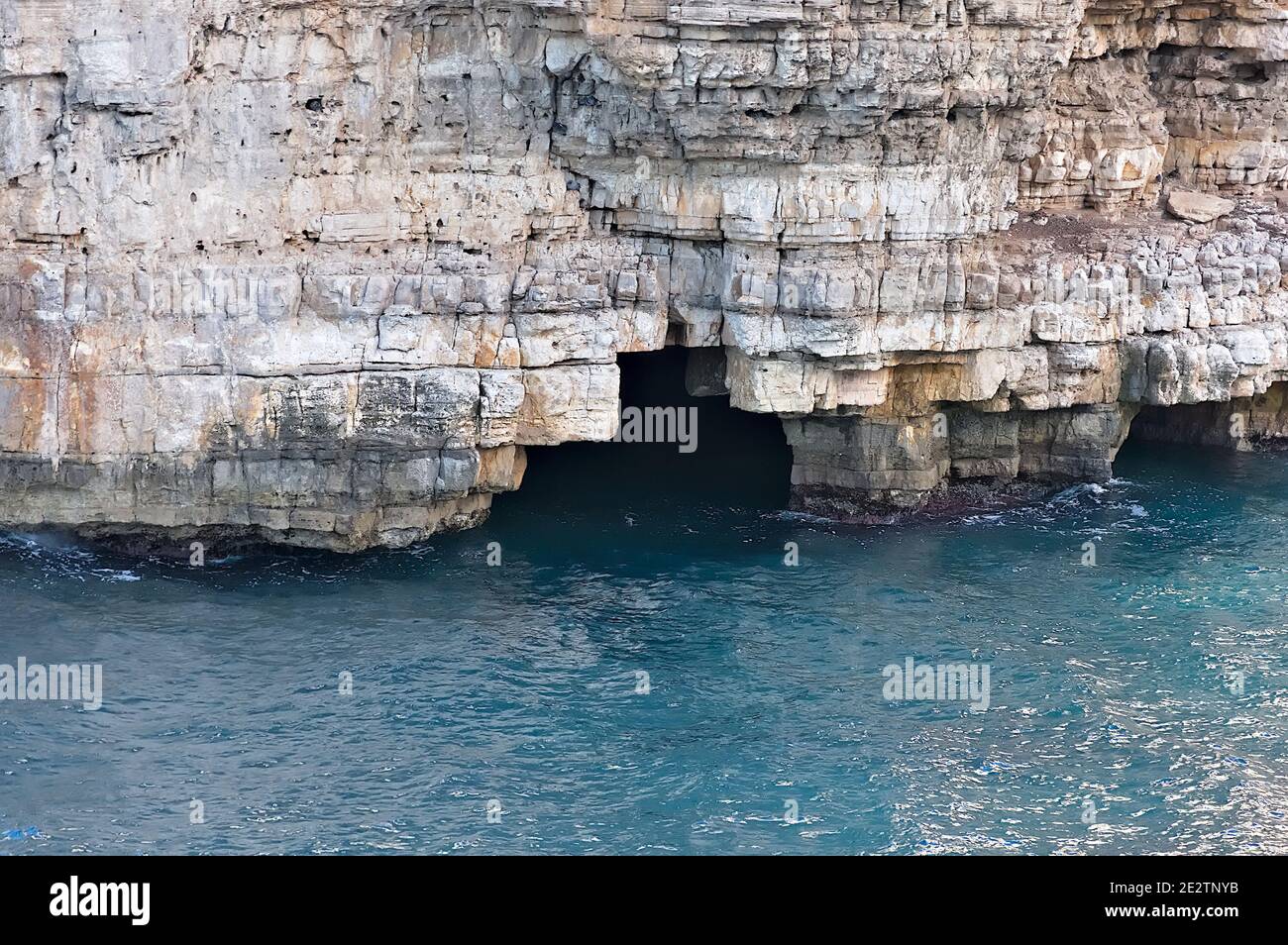 polignano a mare, una bella meta turistica italiana in Puglia. Particolare della costa rocciosa che domina il mare con le sue grotte Foto Stock
