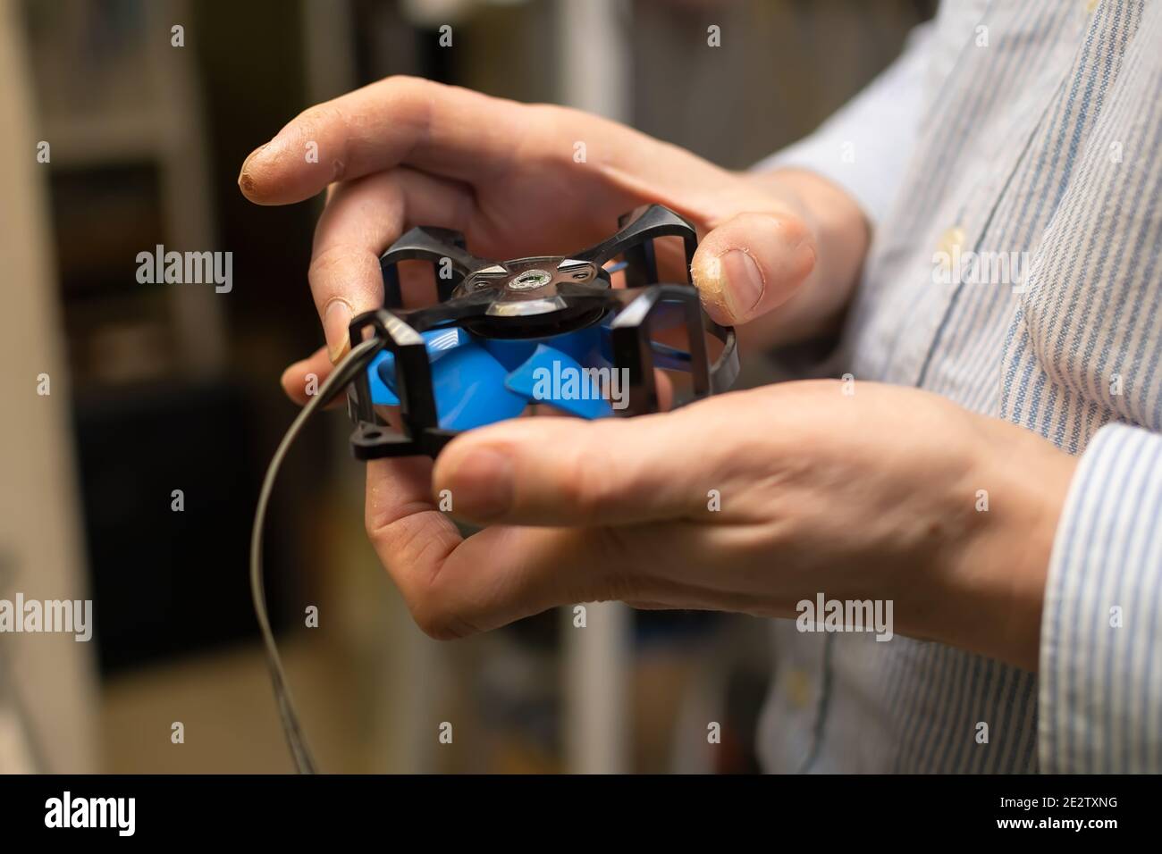 radiatore, ventola dal computer con il cuscinetto aperto per la riparazione e la lubrificazione nelle mani del master del centro di assistenza Foto Stock