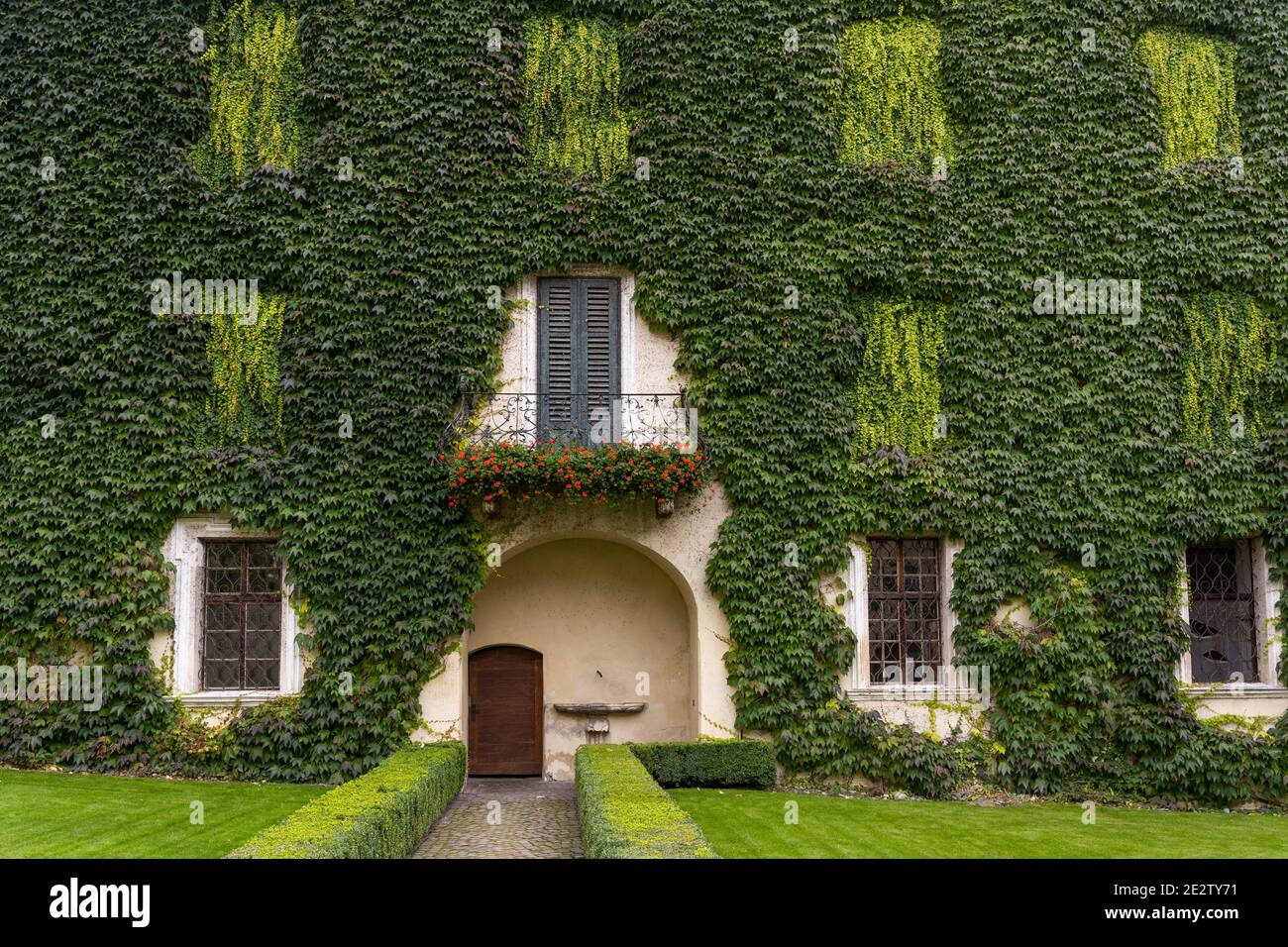 Bressanone, Italia - 9 ottobre 2020: Giardino con casa con scalatore verde, vite, nel monastero di Abbazia di Novacella, Kloster Neustift in autunno in t Foto Stock