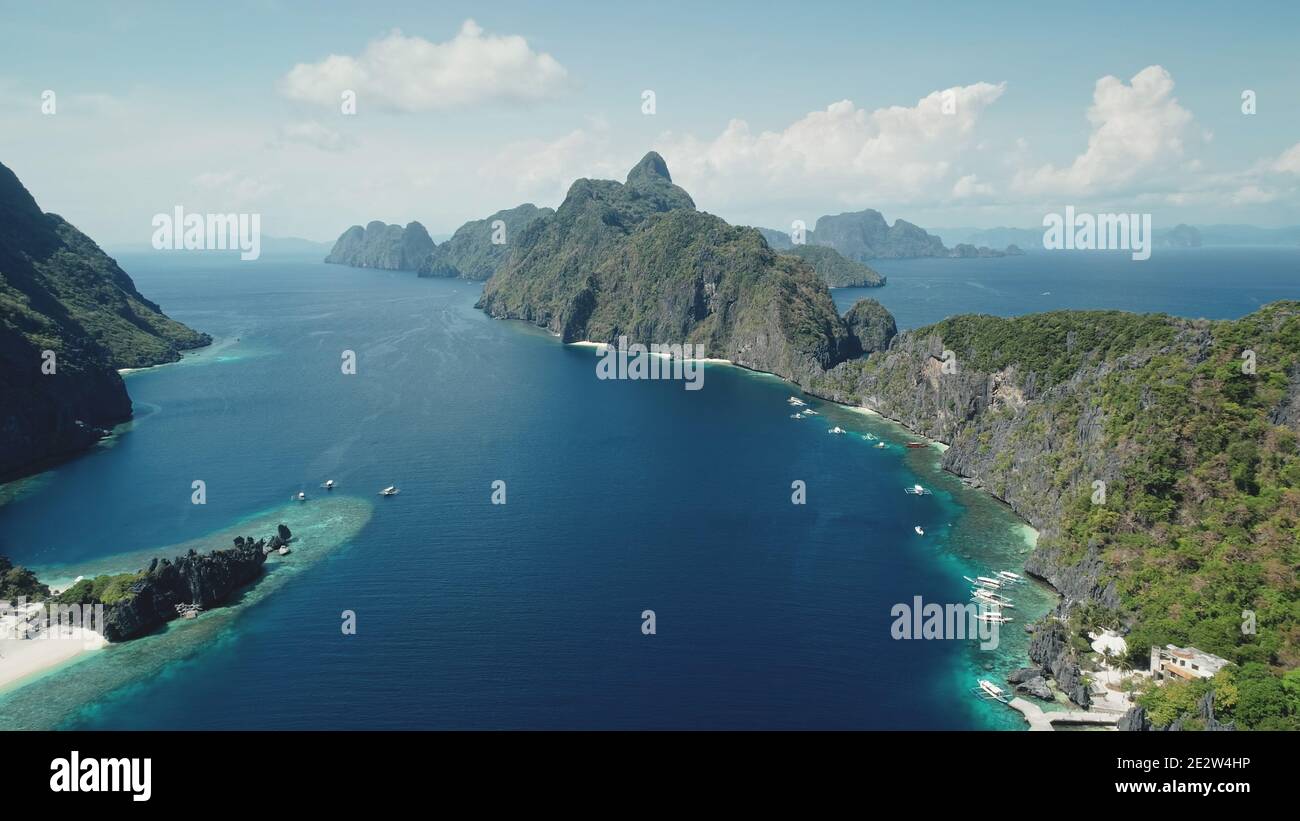 Vista aerea dell'isola di monte sulla costa tropicale del mare. Incredibile paesaggio di Palawan isolotto, Filippine, Asia. Panorama blu acqua della baia dell'oceano con alberi di giungla verde a catene montuose. Paradiso turismo estivo Foto Stock