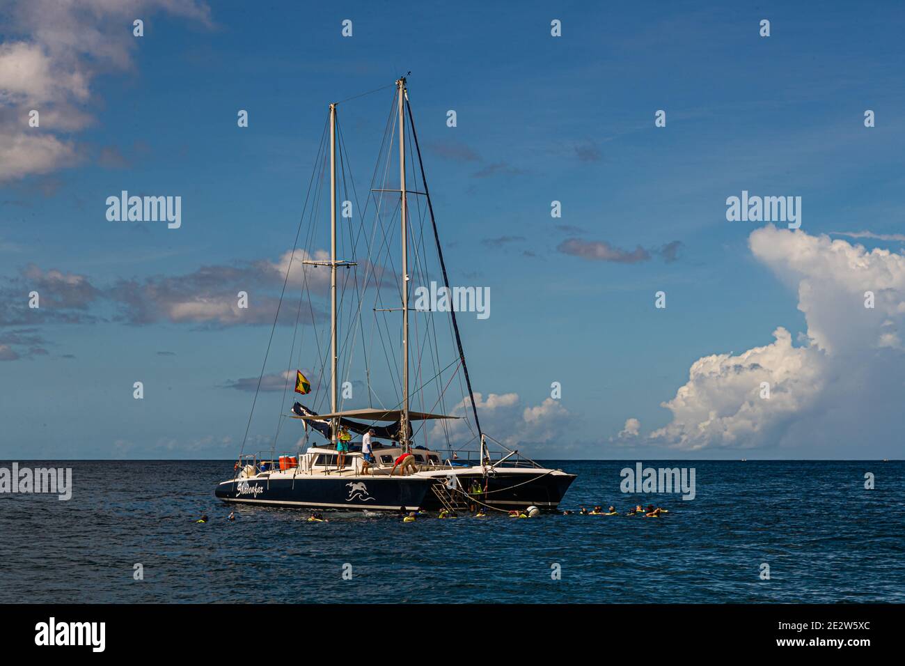 Il catamarano a vela "Shadowfax" è ancorato al largo di Moliniere, Grenada, mentre diversi snorkeller nuotano nell'acqua turchese intorno alla barca. L'operatore Shadowfax Cruises organizza tour guidati di vela e snorkeling lungo la costa da qui. Foto Stock