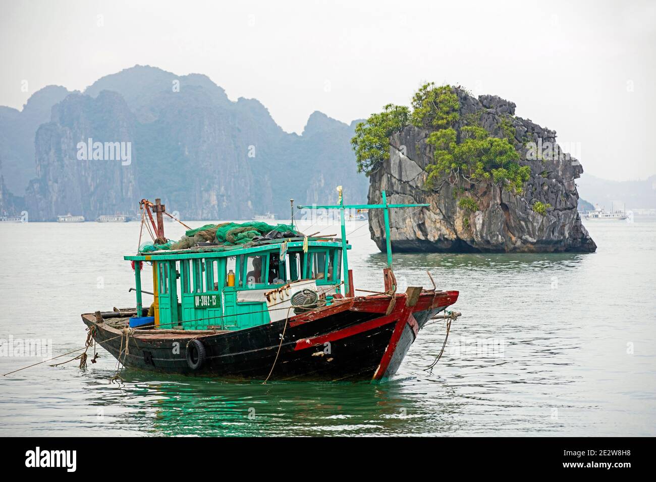 Imbarcazione da pesca in legno e isole monolitiche di pietra calcarea nella Baia di ha Long / Baia di ha Long / Vinh ha Long, provincia di Quang Ninh, Vietnam Foto Stock