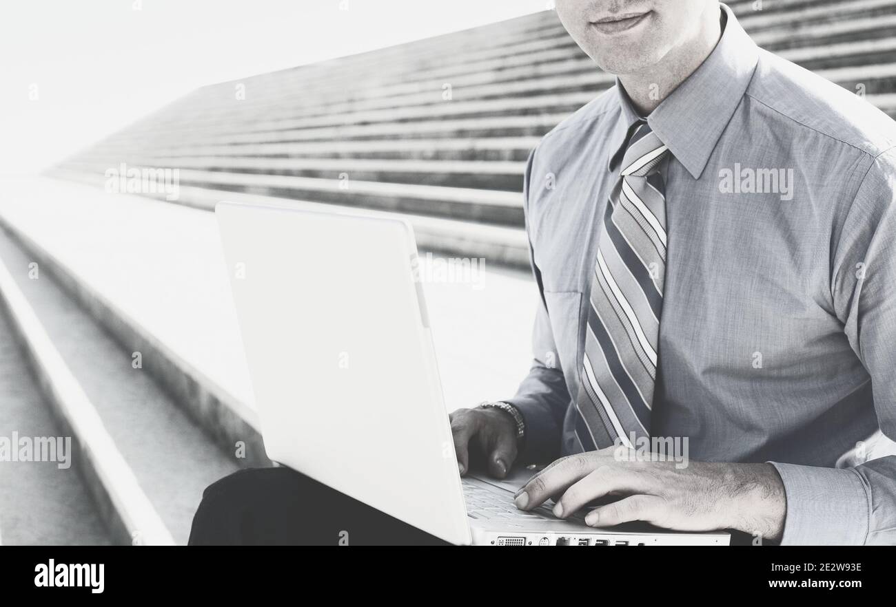 Foto in bianco e nero di un uomo d'affari che utilizza un computer portatile Foto Stock