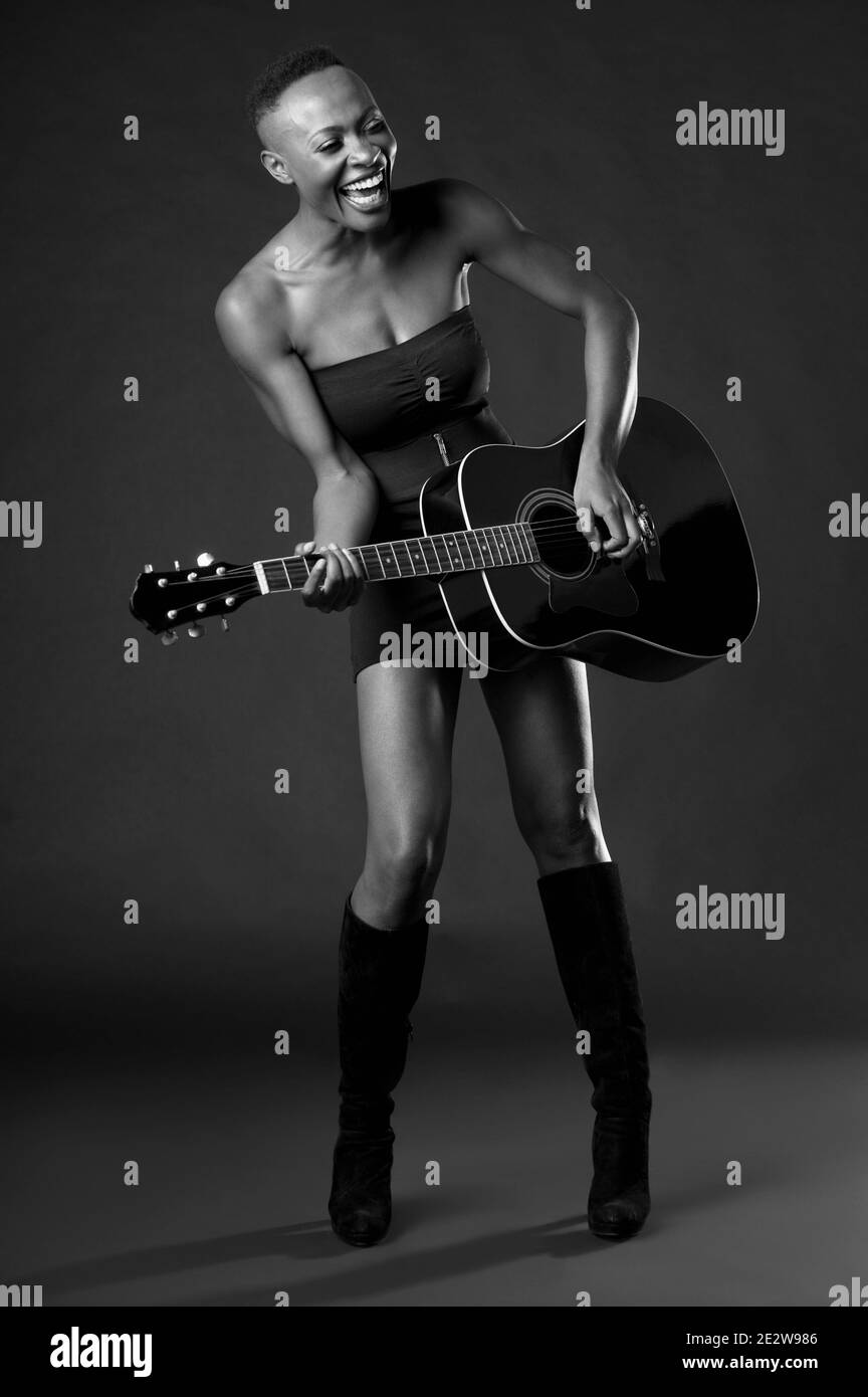 Foto in bianco e nero di una donna afro-americana che suona la chitarra Foto Stock