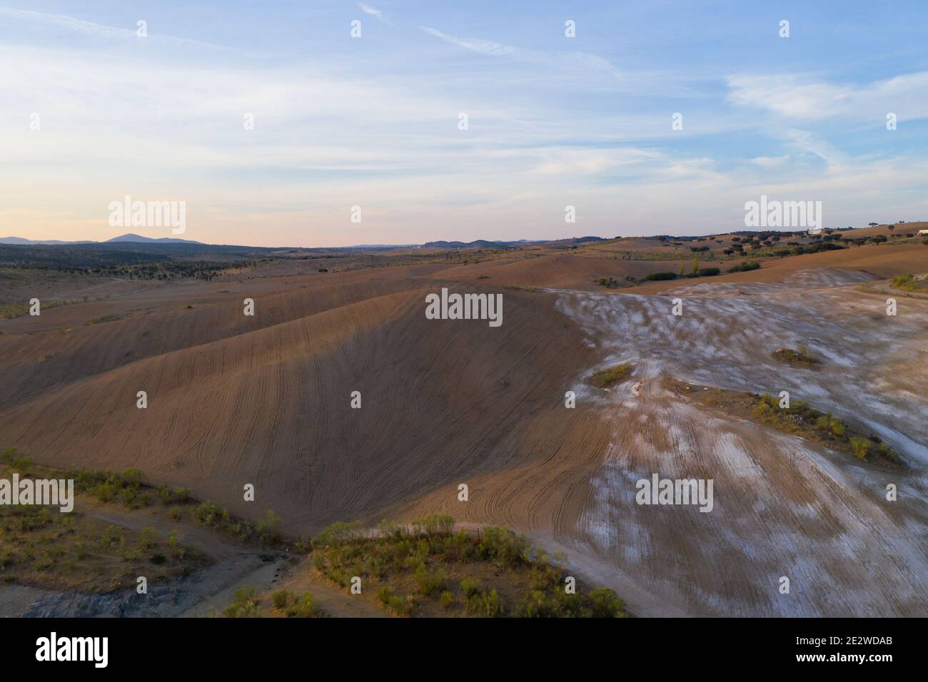 Drone panorama aereo di un deserto come paesaggio collinare con pietre di marmo polvere al tramonto a Terena, Portogallo Foto Stock