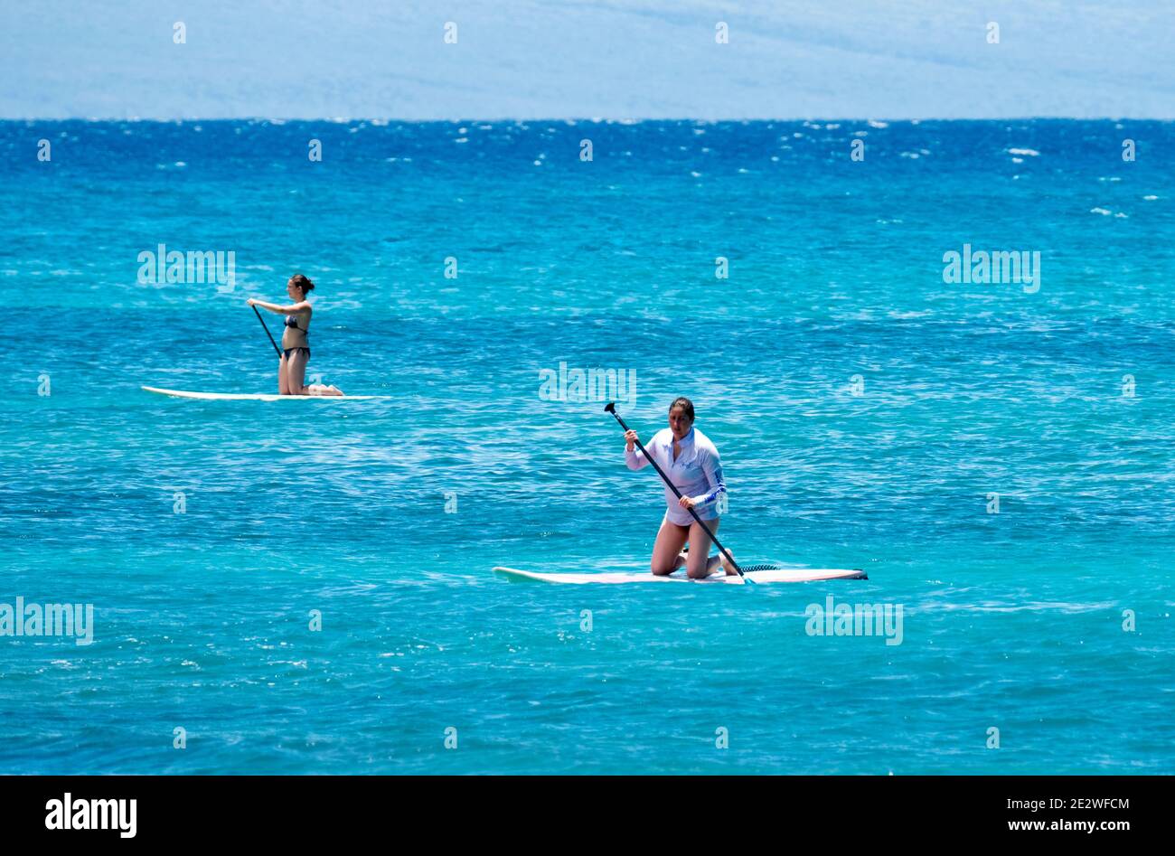 Paddle boarders nella baia di Napili, Hawaii, Stati Uniti. Foto Stock