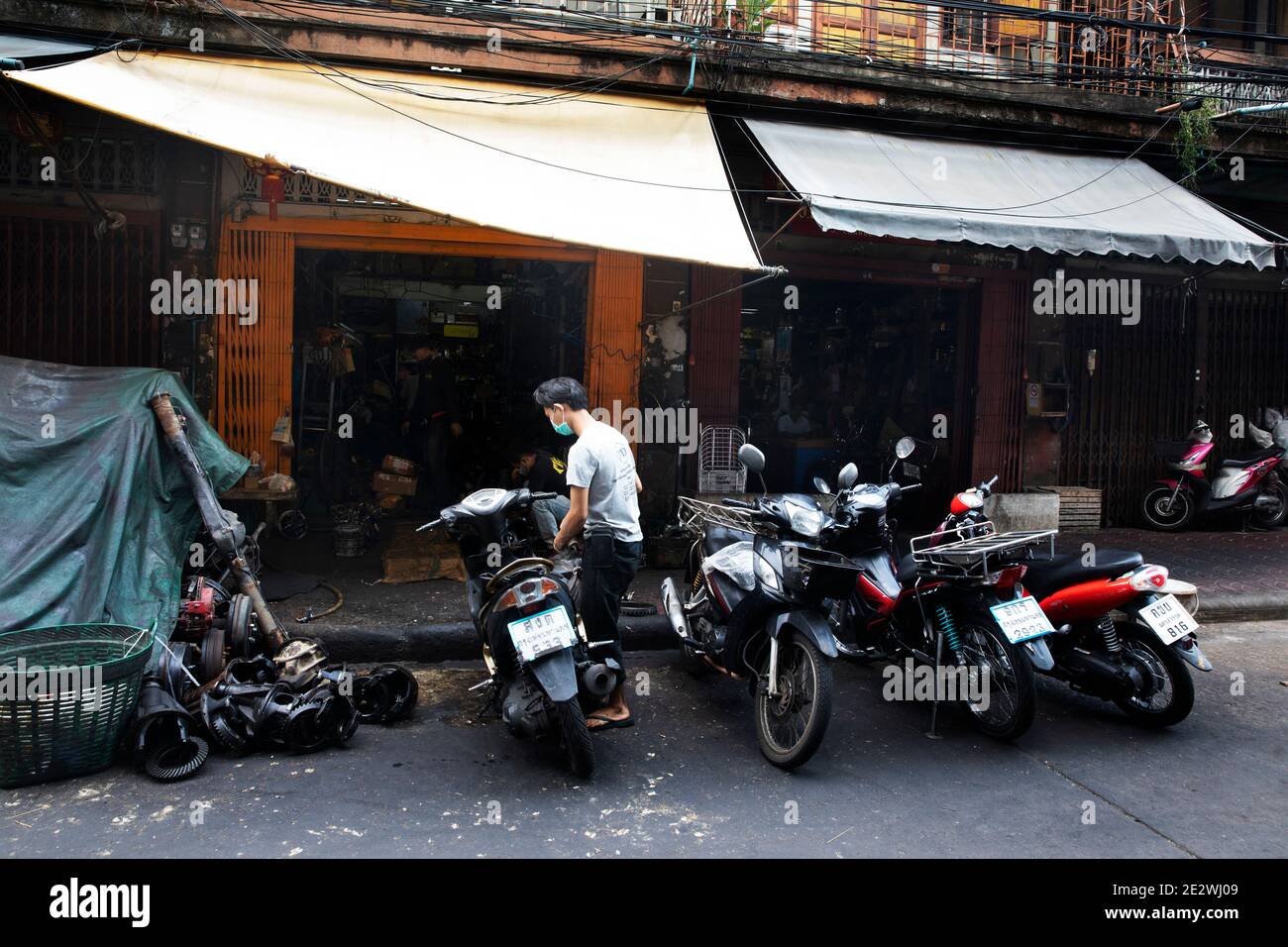 I lavoratori parcheggiano la motocicletta di fronte al negozio di riparazioni automobilistiche di Talat noi Foto Stock