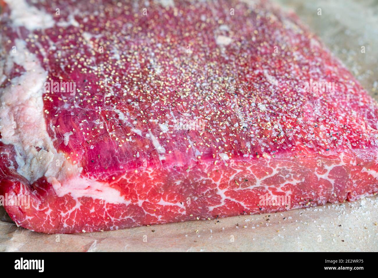 Bistecca cruda fiancata su carta da macello: Filetto di briglia londinese non cotti su carta marrone condito con sale e pepe Foto Stock