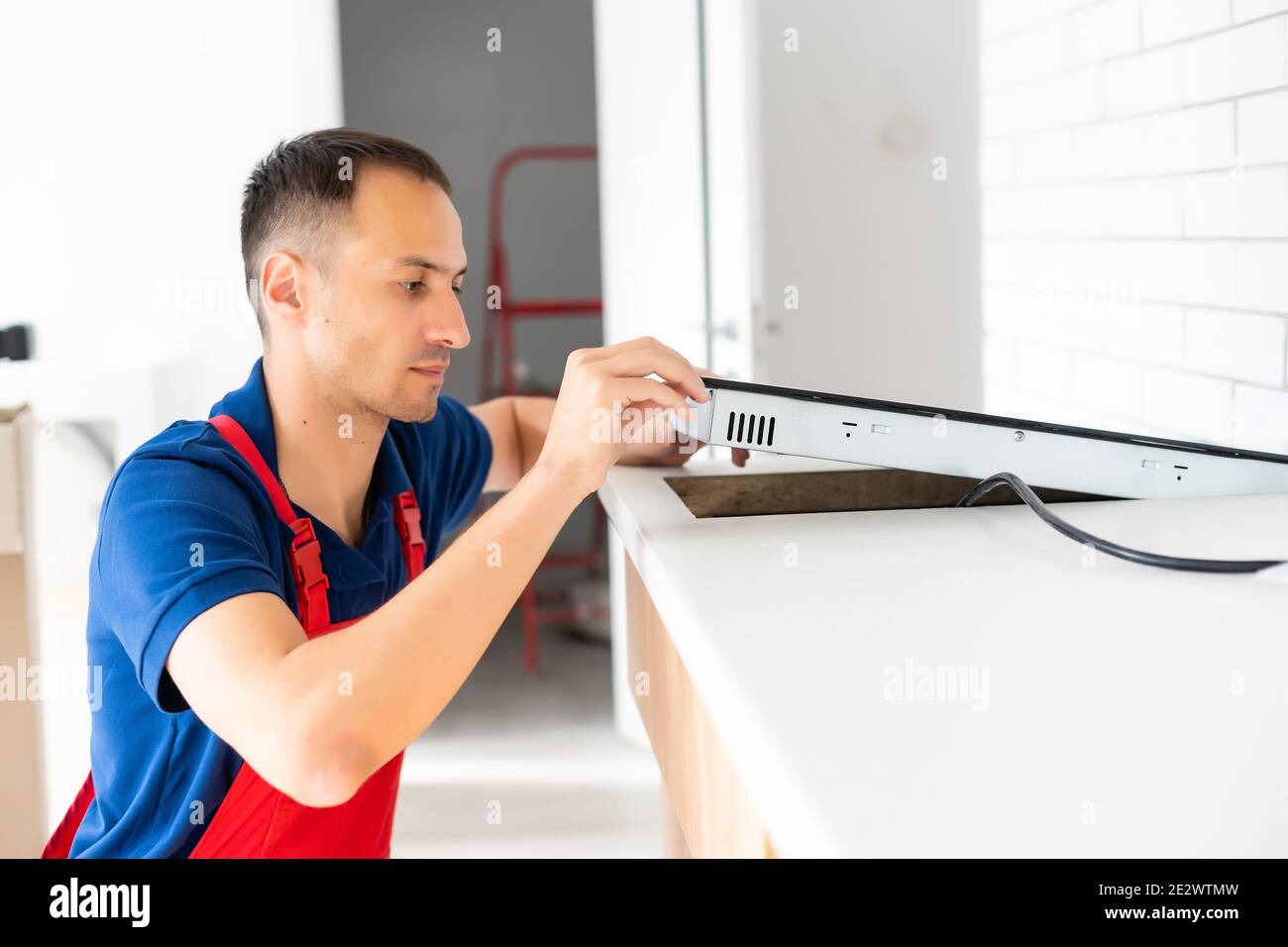Installazione di fornelli a induzione piano di cottura o da parte di un maestro. Foto Stock