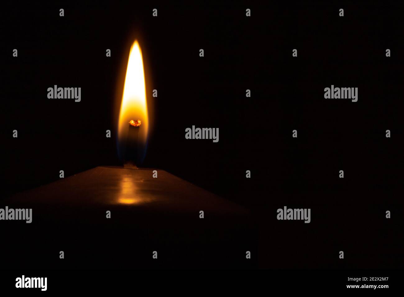 Primo piano di candela fiamma su sfondo nero per la copia spazio Foto Stock