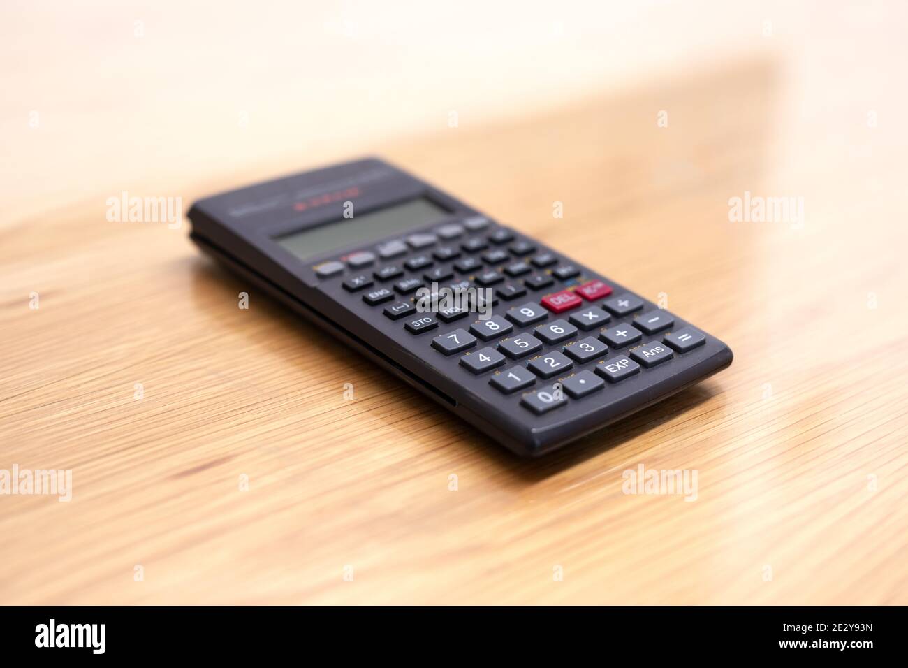 Calcolatrice elettronica su un tavolo di legno. Casa. Foto Stock
