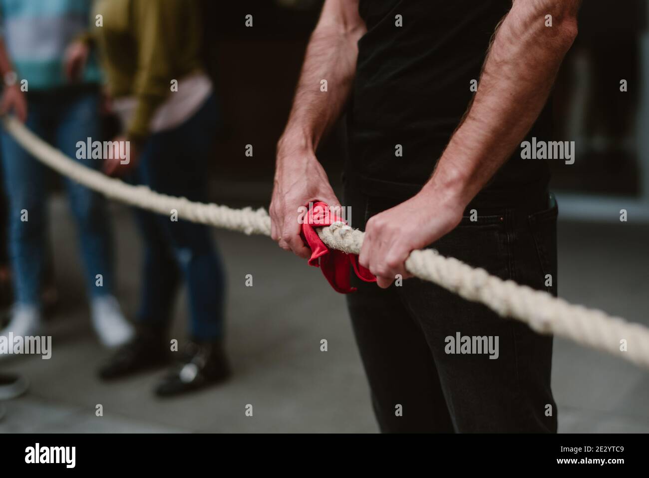 Armi forti che tengono il legame rosso nei Paesi baschi giocando soka tira. Foto Stock