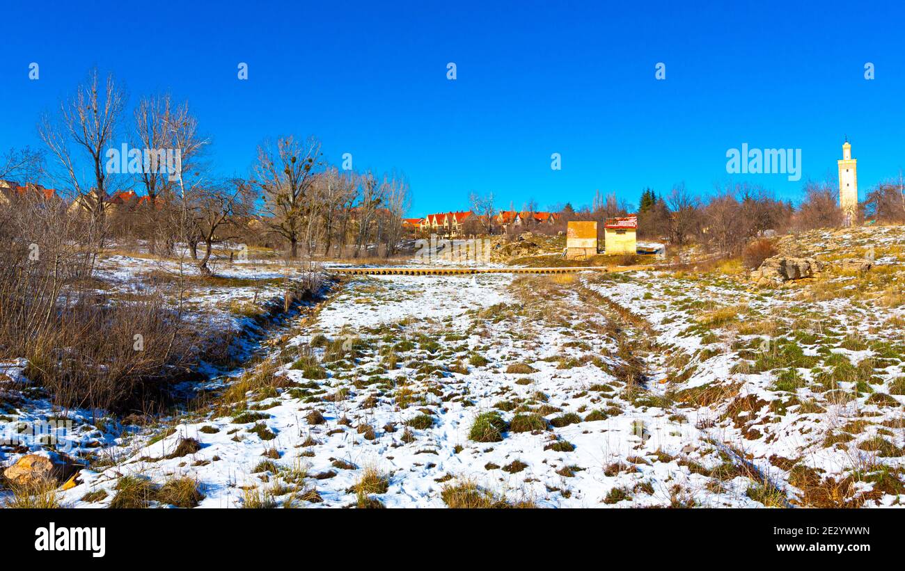 Alberi marroni, neve bianca e un cielo blu nella città di Ifrane Foto Stock