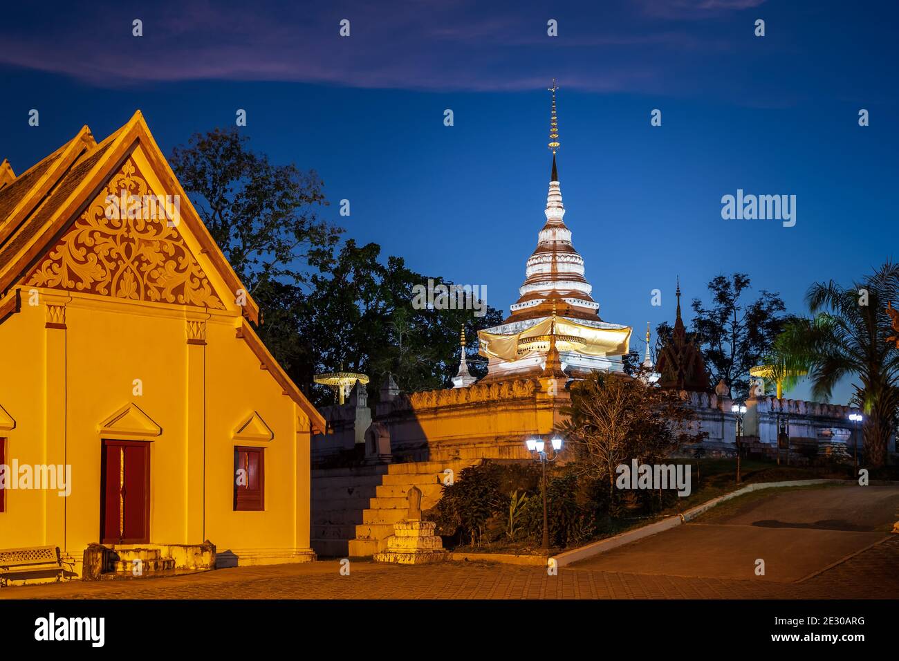 Pagoda d'oro e cappella su collina o montagna a Wat Phrathat Khao noi tempio durante il crepuscolo, provincia di Nan, Thailandia Foto Stock