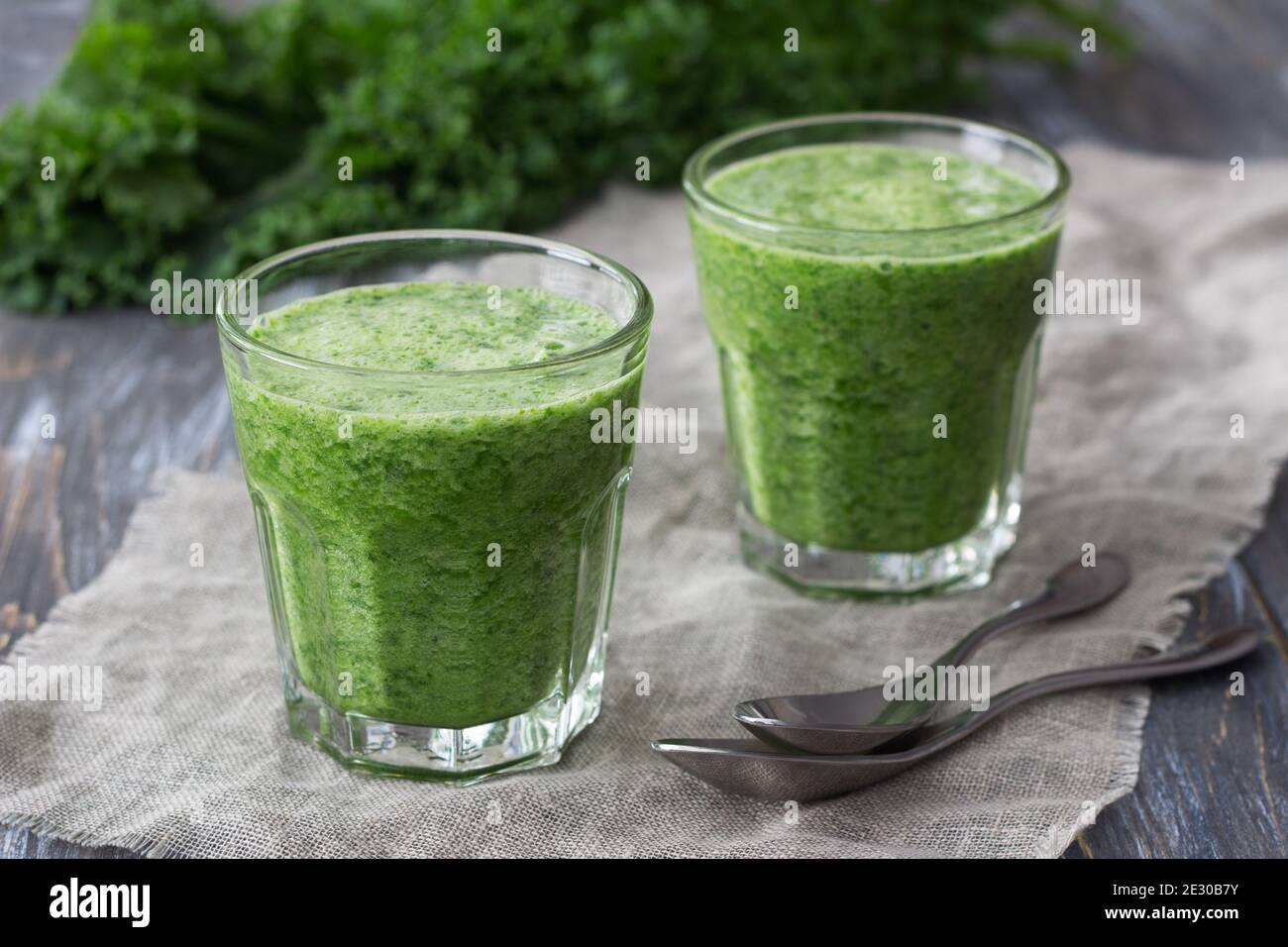 Frappè verdi con kale, banana e limone. Su un tavolo di legno. Fuoco selettivo. Cibo sano di dieta Foto Stock