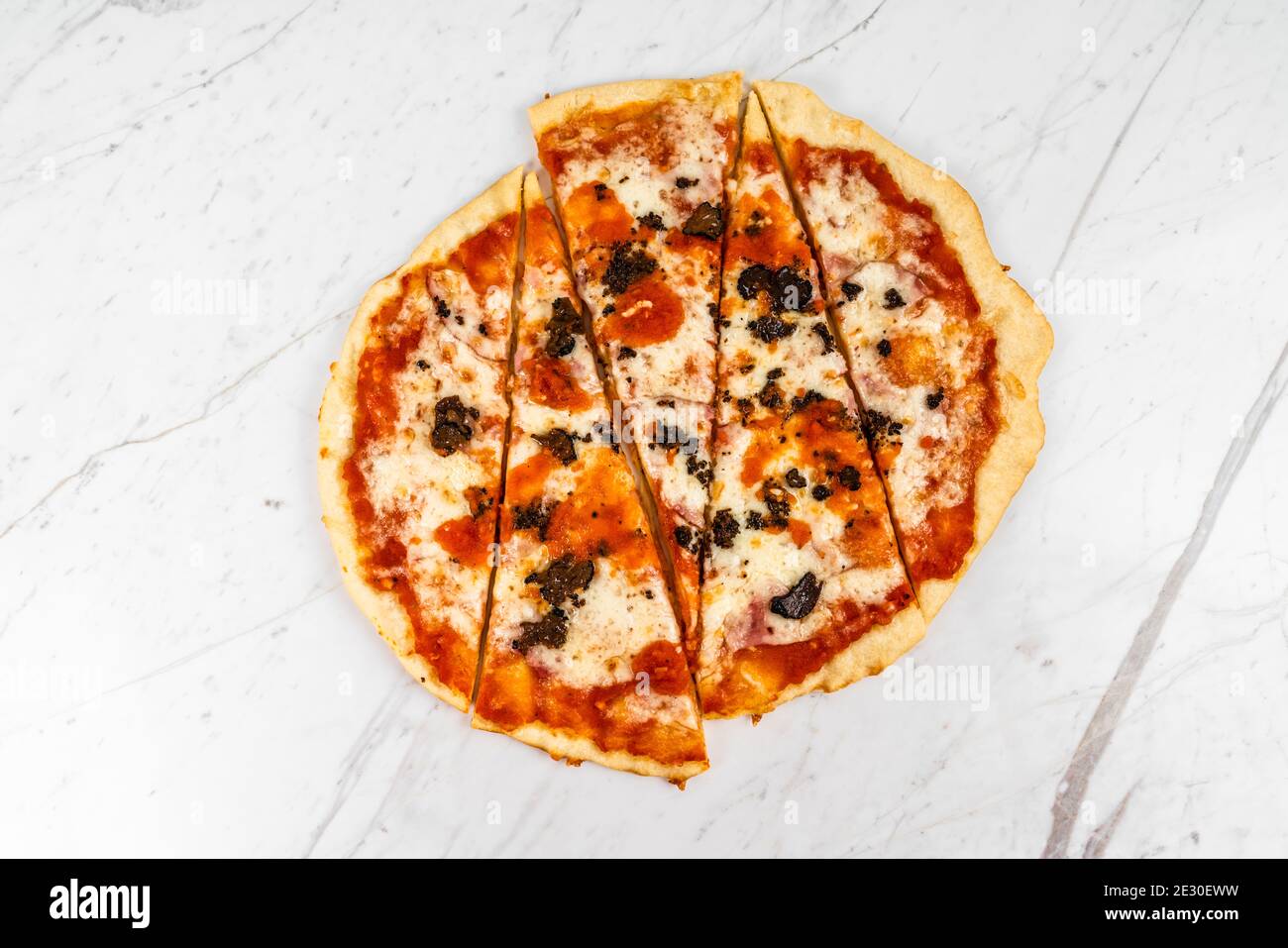 Pizza a fette, funghi al tartufo con salsa di pomodoro e formaggio su sfondo in marmo bianco Foto Stock